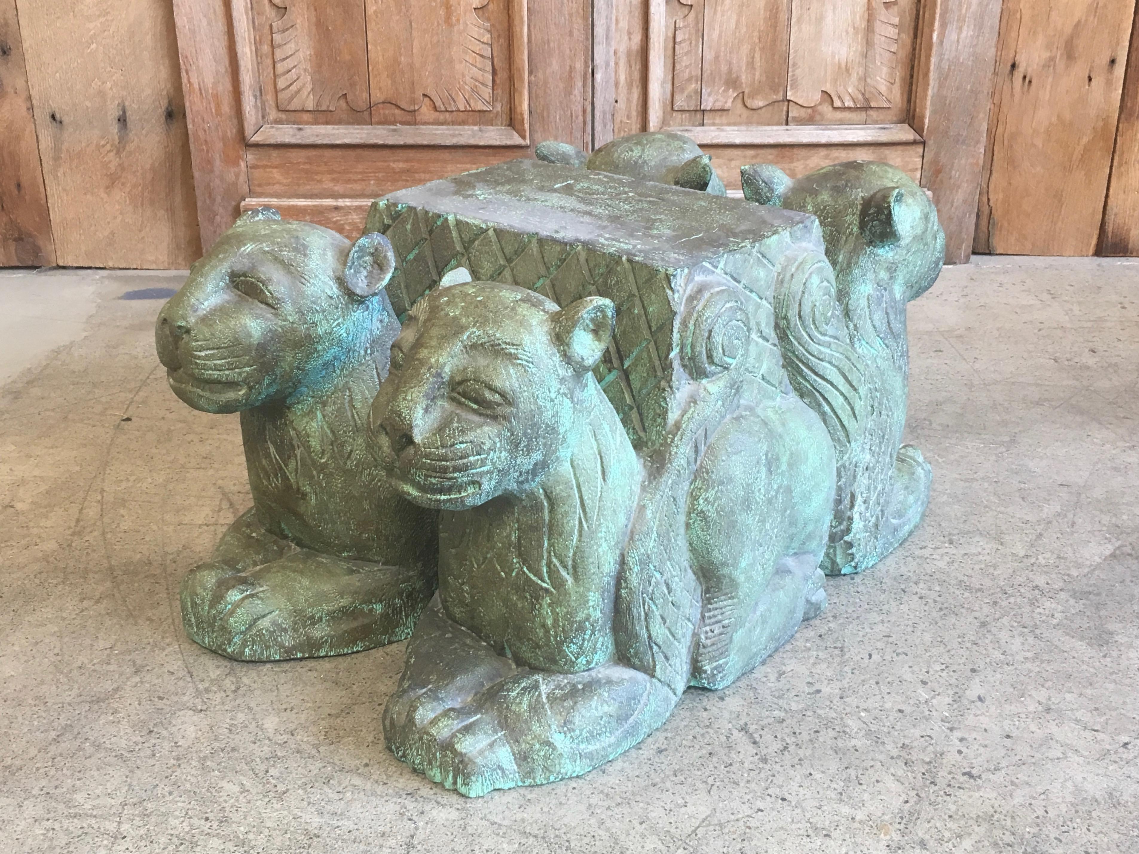 Solid wood carved into four intersecting lions with a verdigris finish and glass top.