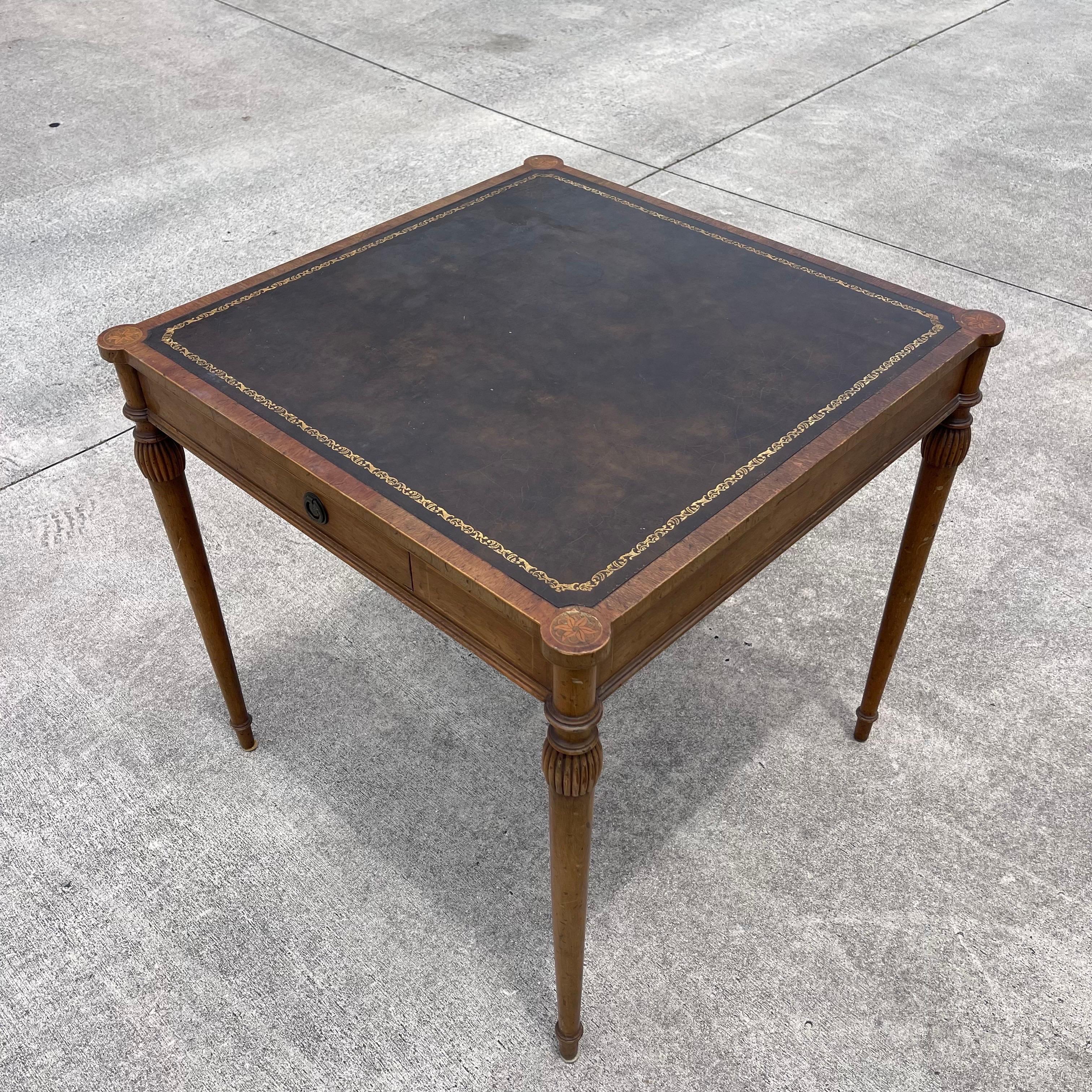 Handmade game table featuring charming inlay work and a tooled leather top. Two drawers on opposing sides.
