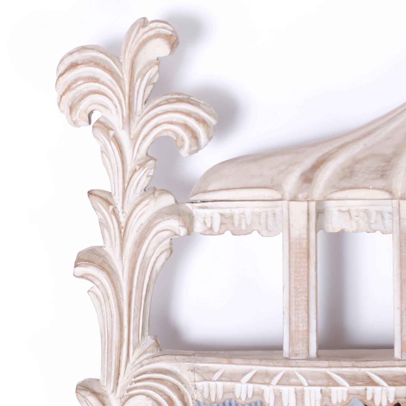 Vintage Italian carved wood wall mirror with a white washed or lime finish over a carved floral frame topped with plumes and a center crest with architectural elements.