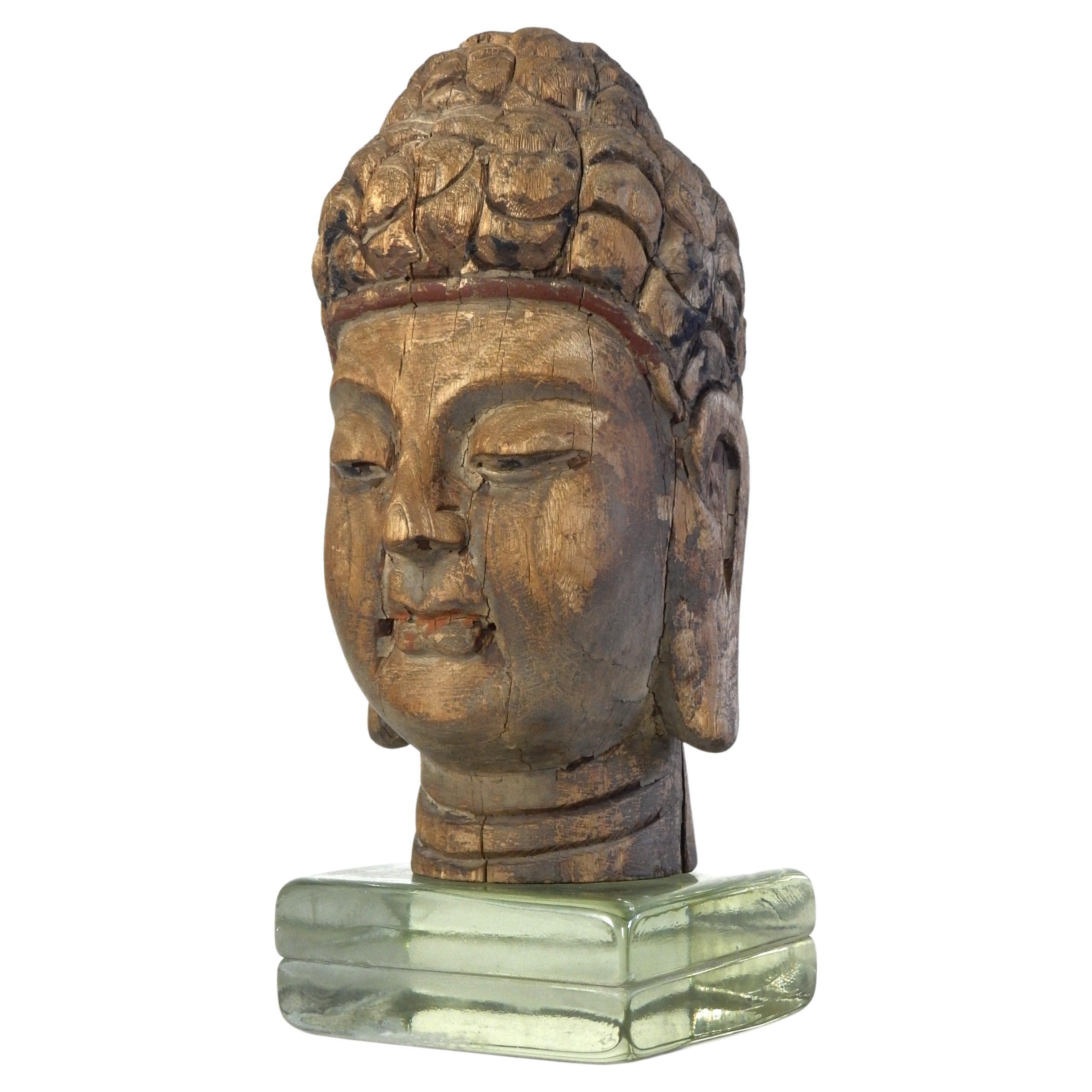 Tête de Bouddha en bois sculpté et fragment de temple polychrome 