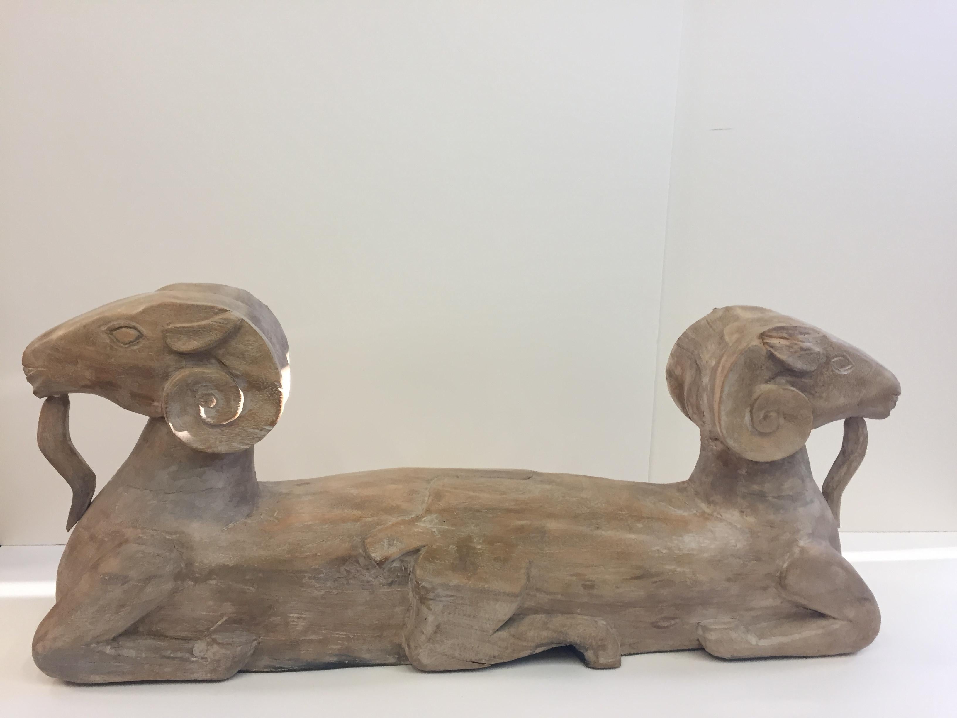An impressive natural wood sculpture, elongated linear shape with Egyptian rams heads at either end. Great on a console.