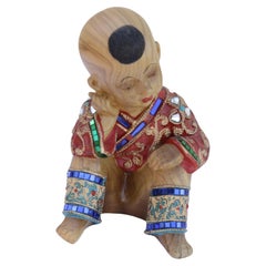 Figure assise en bois sculpté en vêtements ornés de bijoux