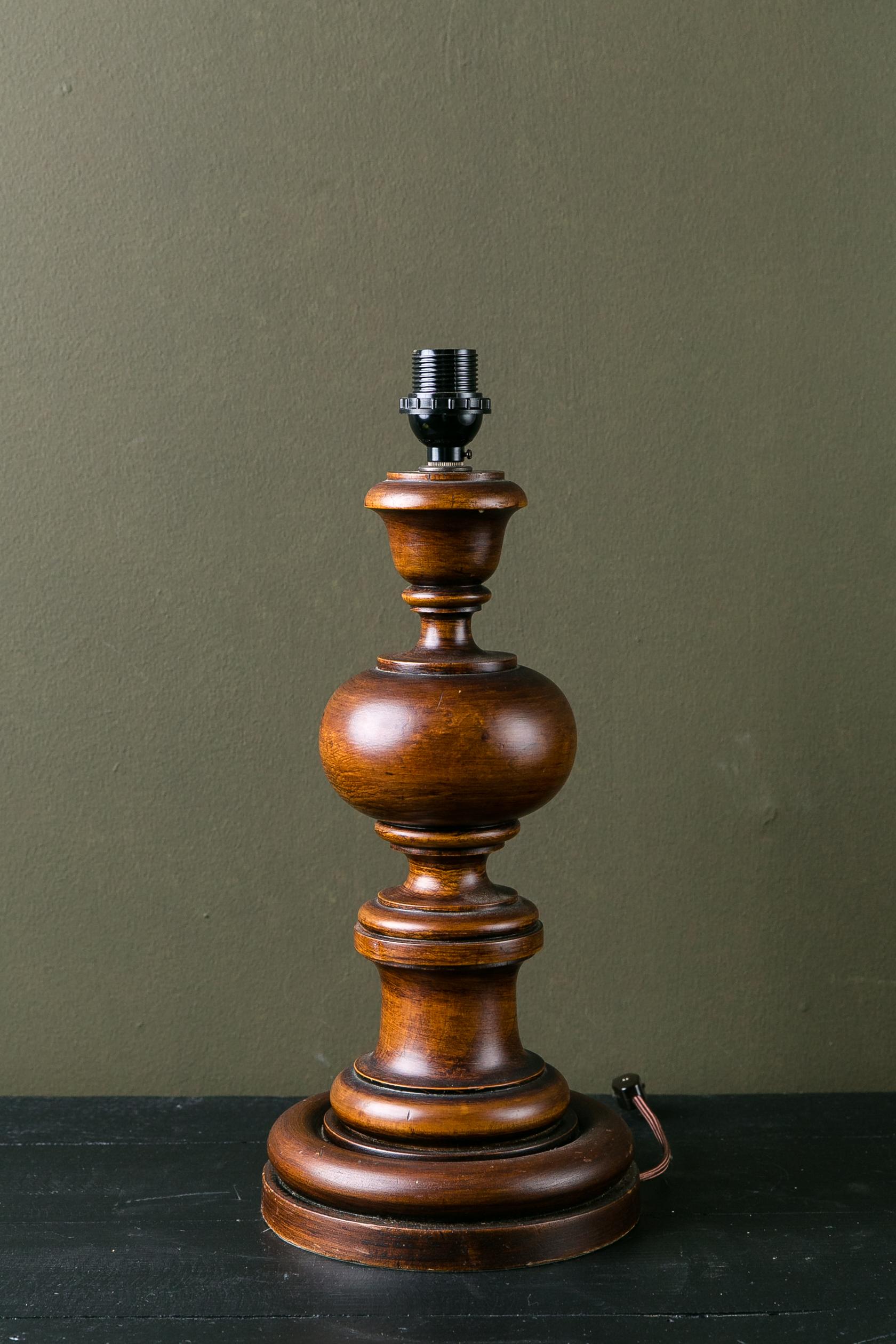 This carved wood lamp was made in Italy but could have come from many different countries. It has been wired in the US using a phenolic socket. The lamp is a classic that could be in a country or city house. The lamp could be American Colonial,