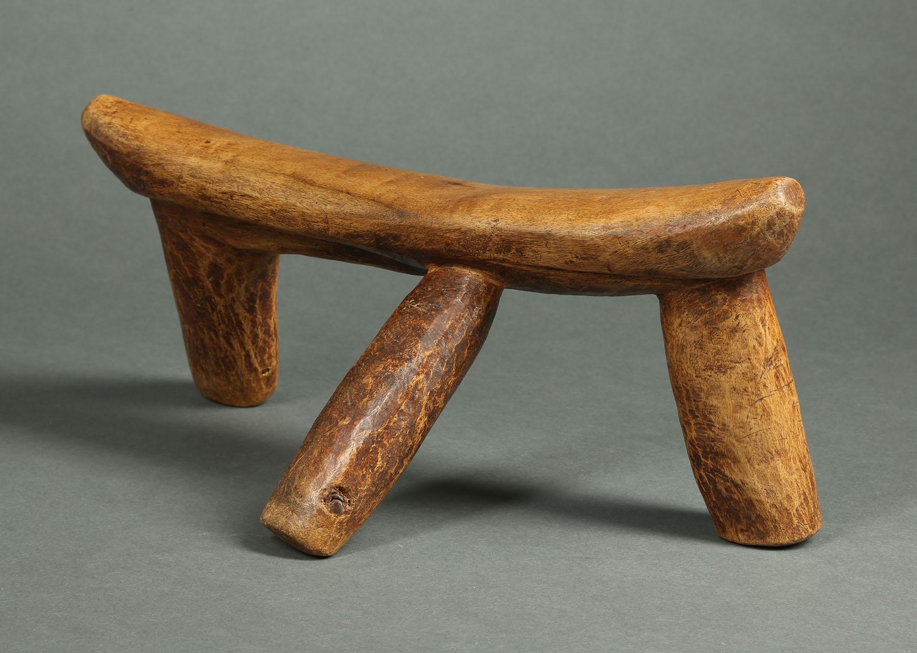Carved wood tribal three leg headrest, Kenya

A wonderful, worn used three leg headrest from Kenya, about 14 inches long.