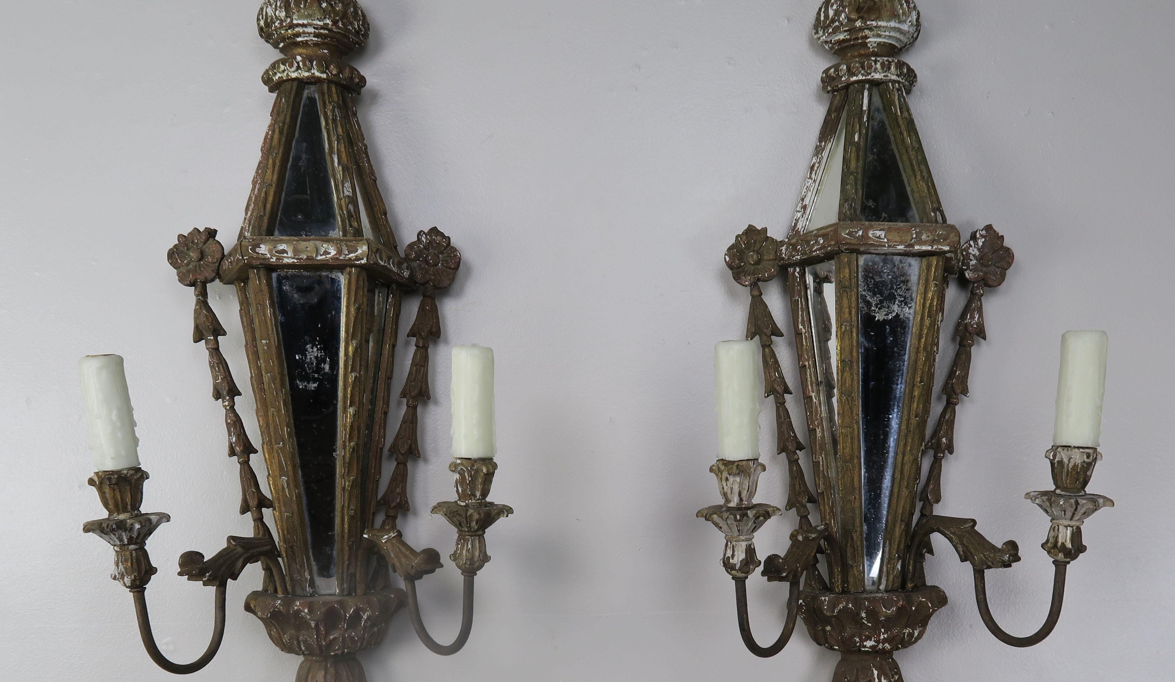 A pair of carved wood Venetian mirrored two light sconces that are beautifully carved with a shell motif at top and intricate carved details throughout. The sconces are newly rewired with drip wax candle covers and ready to install.