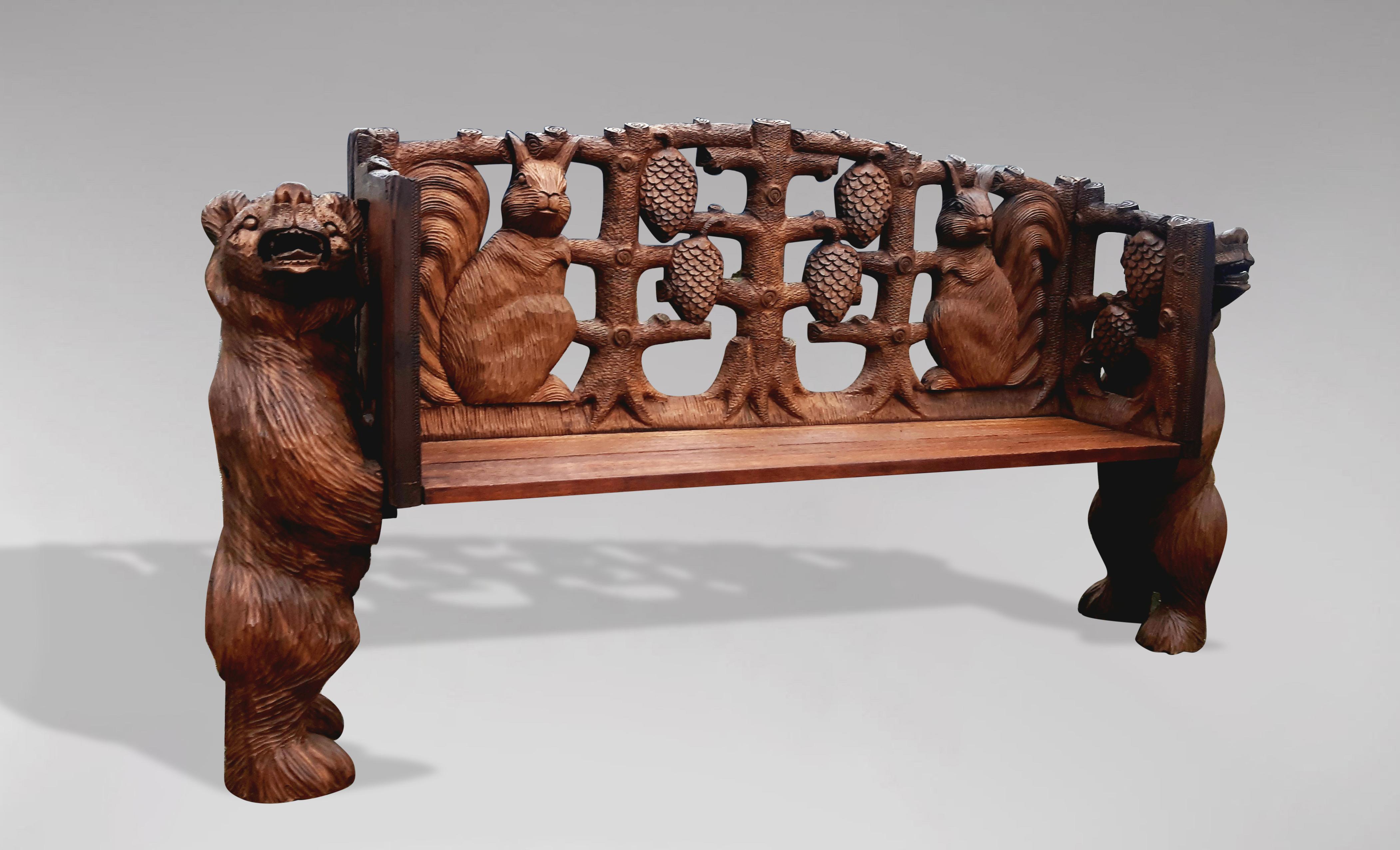 Hand carved wooden bench in the style of the Black Forest, representing two bears supporting the bench, openwork back and carved with two squirrels and four pine cones. Waxed and restored by our workshop.