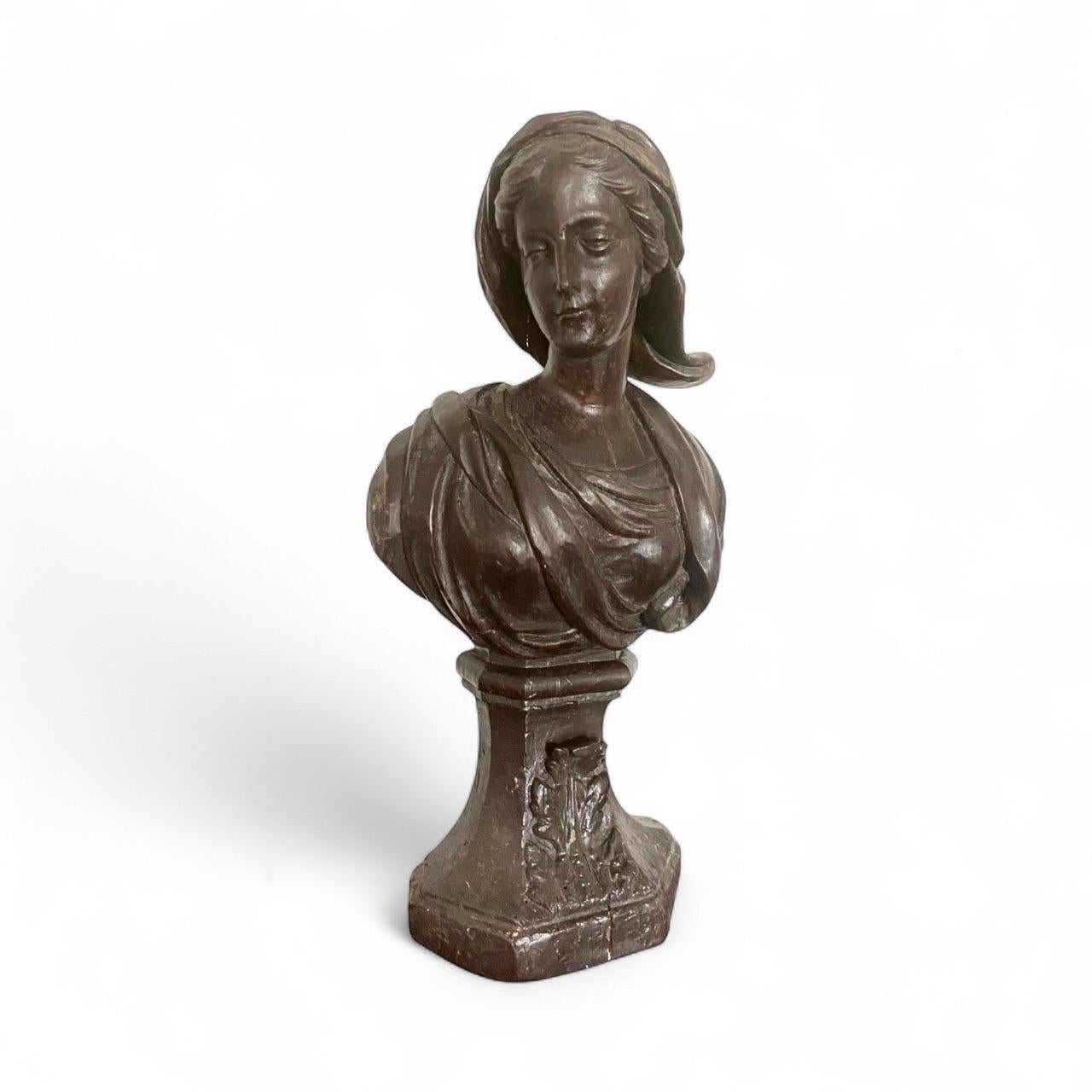 Elegante geschnitzte Frauenbüste aus Holz aus der Zeit Ludwigs XIV. (Ende 17. - Anfang 18. Jahrhundert). Dieses dekorative Werk zeigt eine junge Frau, die einen Schleier trägt, der anmutig über ihre Schulter fällt. Ihr Gesicht ist leicht geneigt und