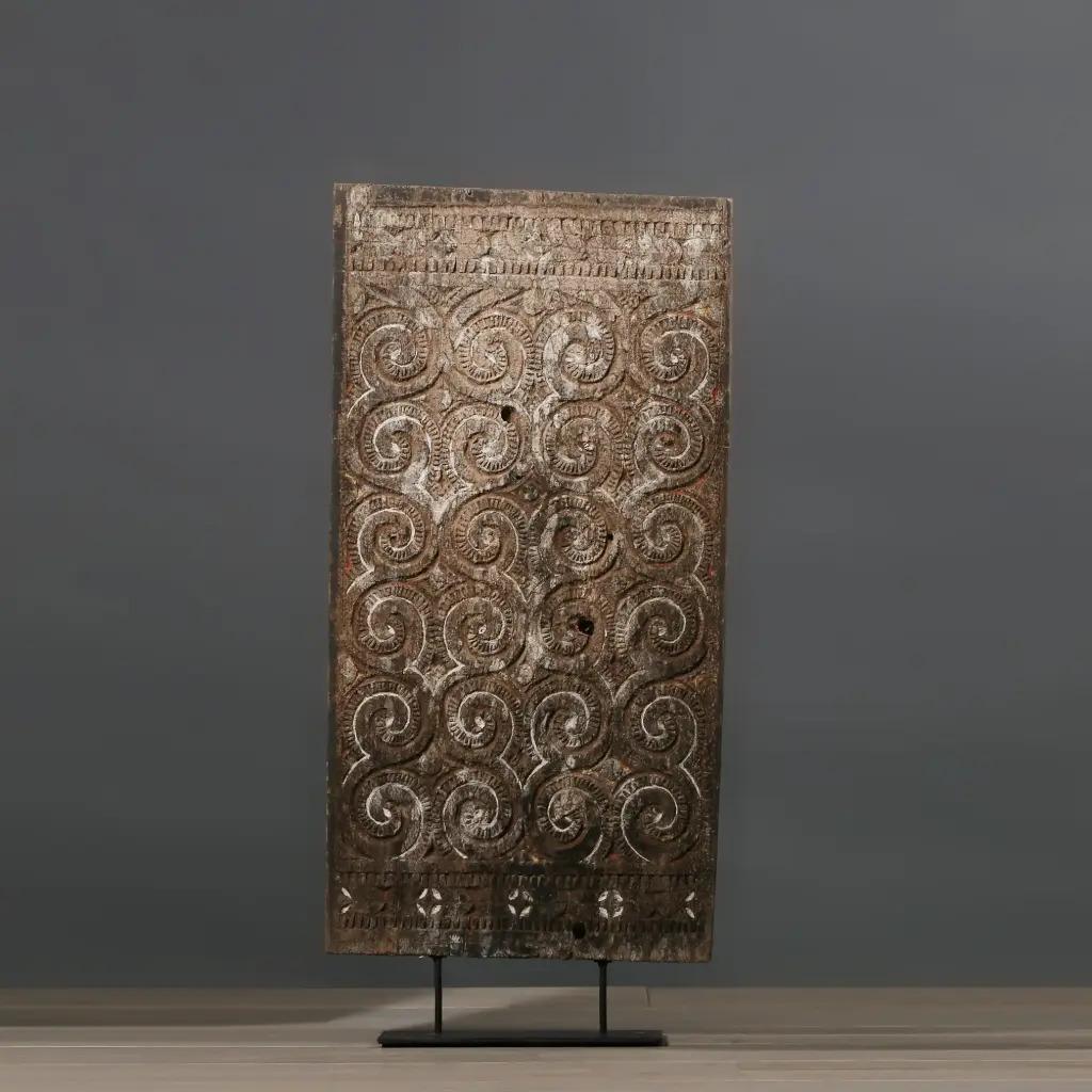 This primitive Toraja carved wooden panel, faded model in M size, is an authentic decorative piece inspired by traditional houses in South Sulawesi, Indonesia. Originally brightly colored, such panels indicated the social rank of families. Its