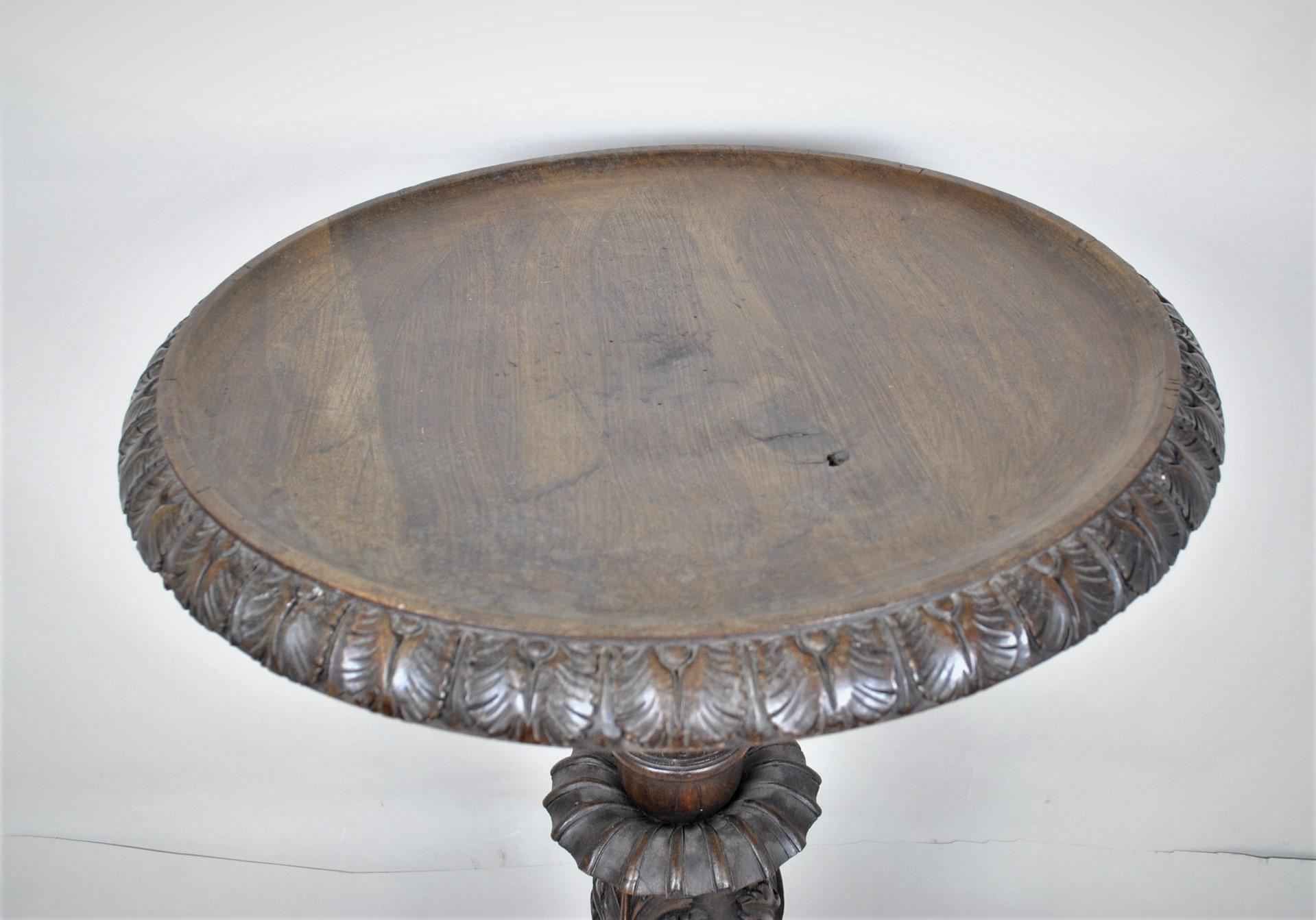 Wooden pedestal table carved with snake heads and glass eyes on the base

Italian folk art, 19th century

Wear and missing parts, one piece replaced under the top; traces of woodworm (treated)

Height 73cm
Diameter 56cm