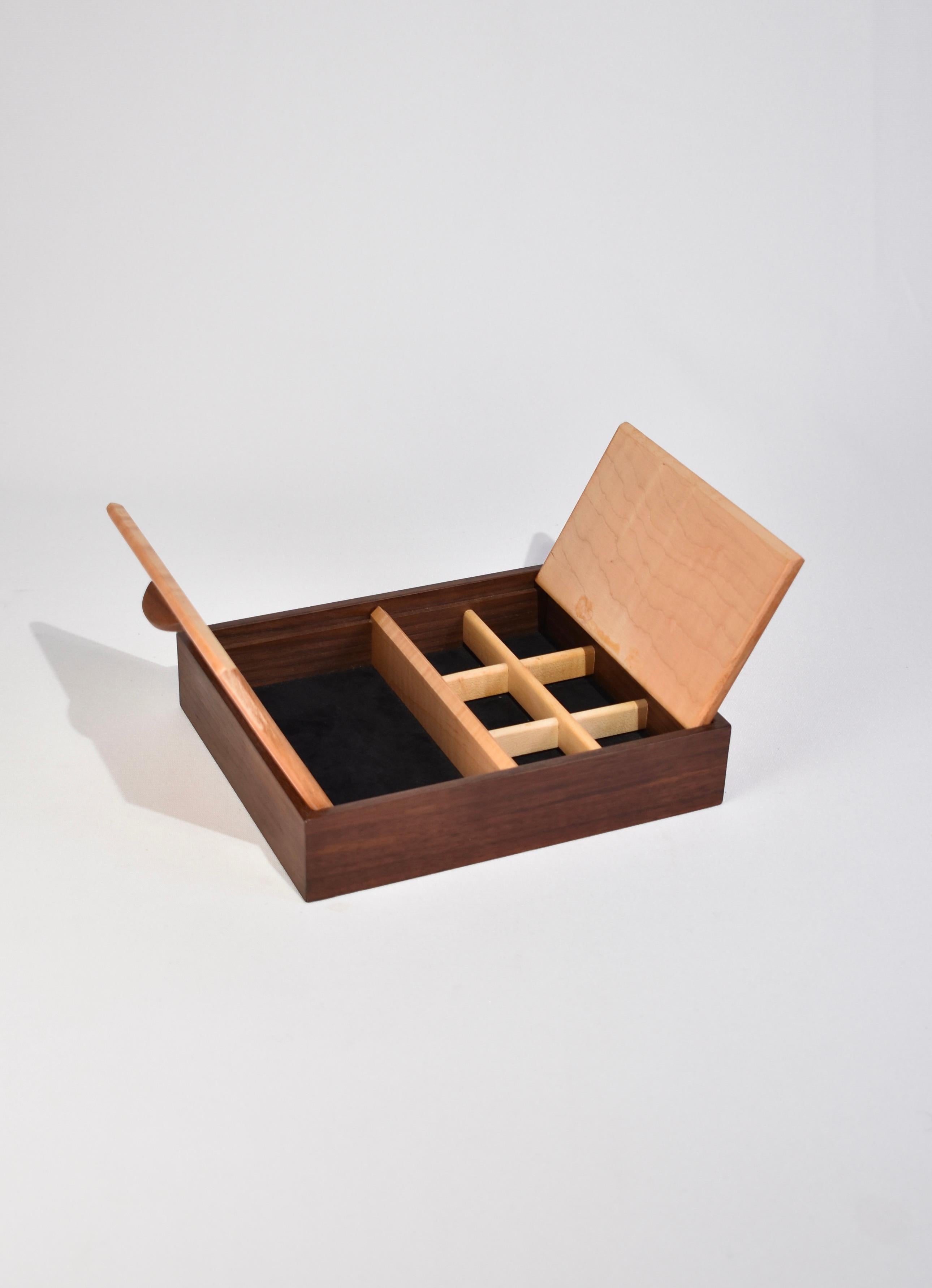 Vintage two-toned wooden jewelry box with interior compartments lined in black felt. Signed on base.