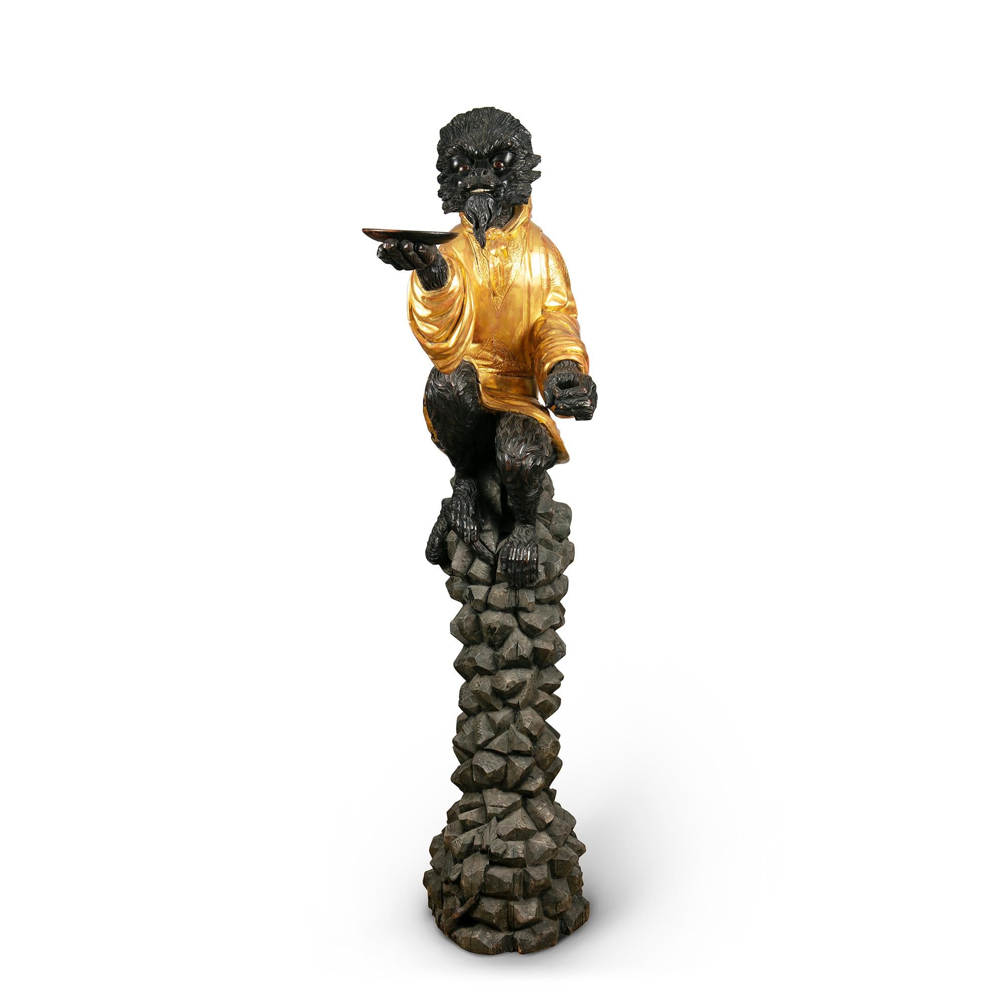 Nicholas Wells antiques is pleased to offer this naturalistically carved figure of a seated monkey wearing a carved giltwood cloak and perched on a rocky plinth, with his hand out holding a dish. Amazing attention to detail and Fine treatment of