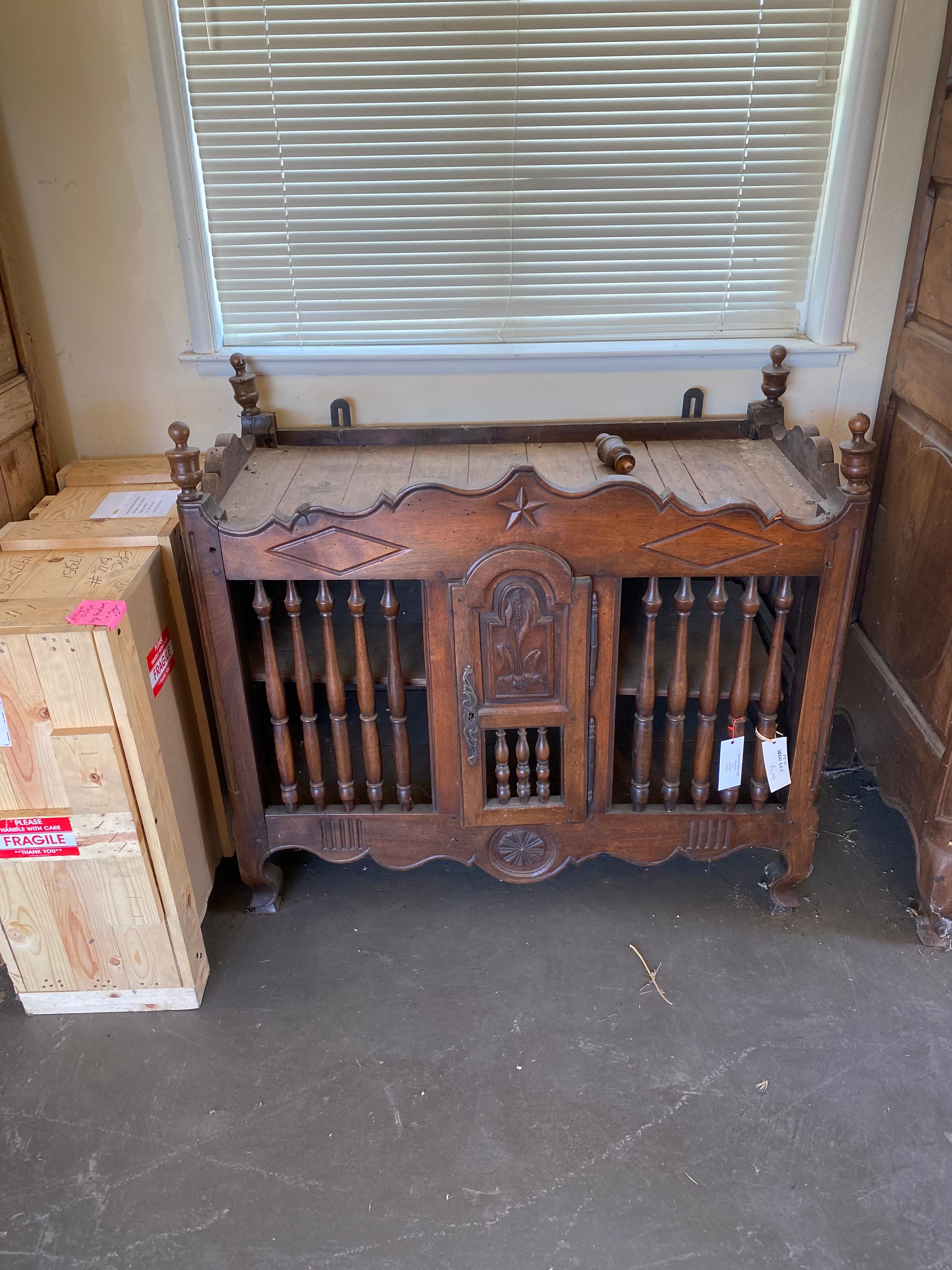 Carved wooden bread rack.  Can be secured to wall for stability.  Wonderful carved details include a bas relief star in the center, an ear of corn on the door and a sunburst medallion on the bottom.  The rack has finials on the top corners and