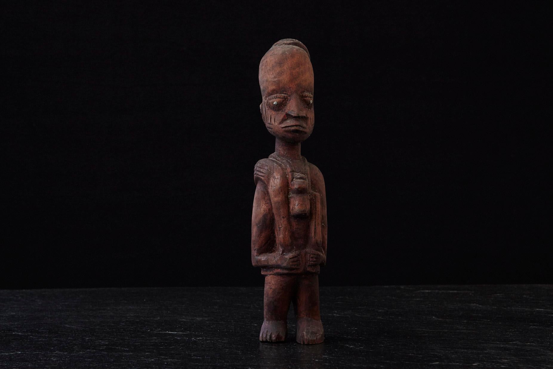 Große handgeschnitzte Holzstatue eines Ju-Ju-Mannes, hergestellt vom Volk der Egba in Abeokuta, Ogun State (Teil von Nigeria), um 1940.
Die Pupillen sind aus Nägeln gefertigt, was das Aussehen und den Ausdruck des Ju-Ju-Mannes noch verstärkt,
