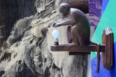 carved wooden wall light representing a sitting monkey