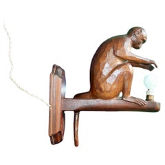 carved wooden wall light representing a sitting monkey