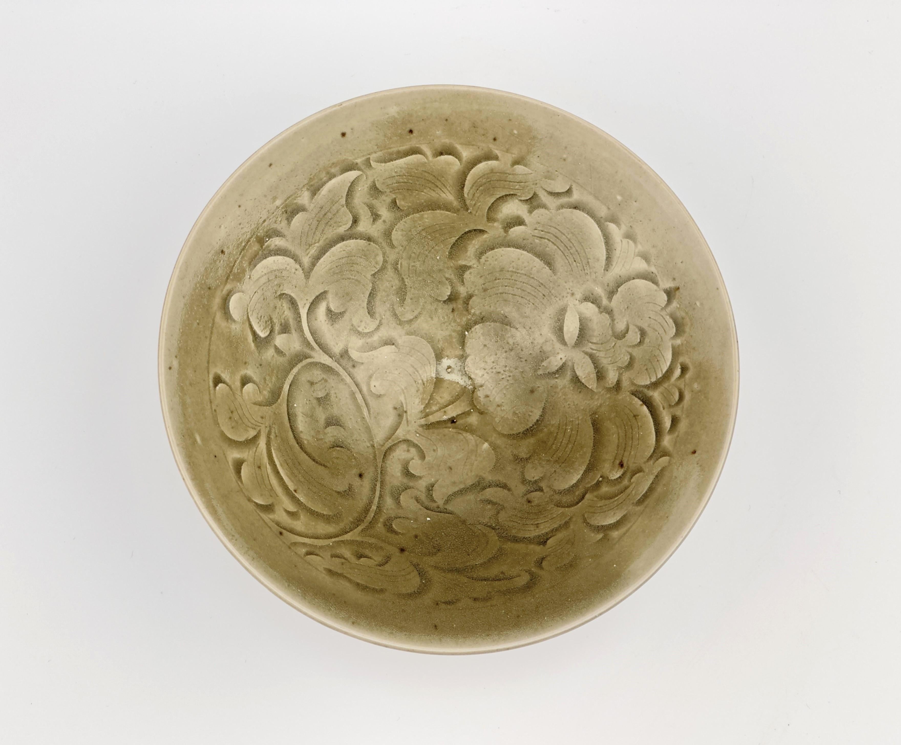 The bowl is potted with steep, flared sides and decorated to the interior with stylized peonies among scrolling tendrils. The exterior is carved with vertical lines below the everted mouth rim.

Period : Song Dynasty (AD 960~1279)
Type : Yaozhou