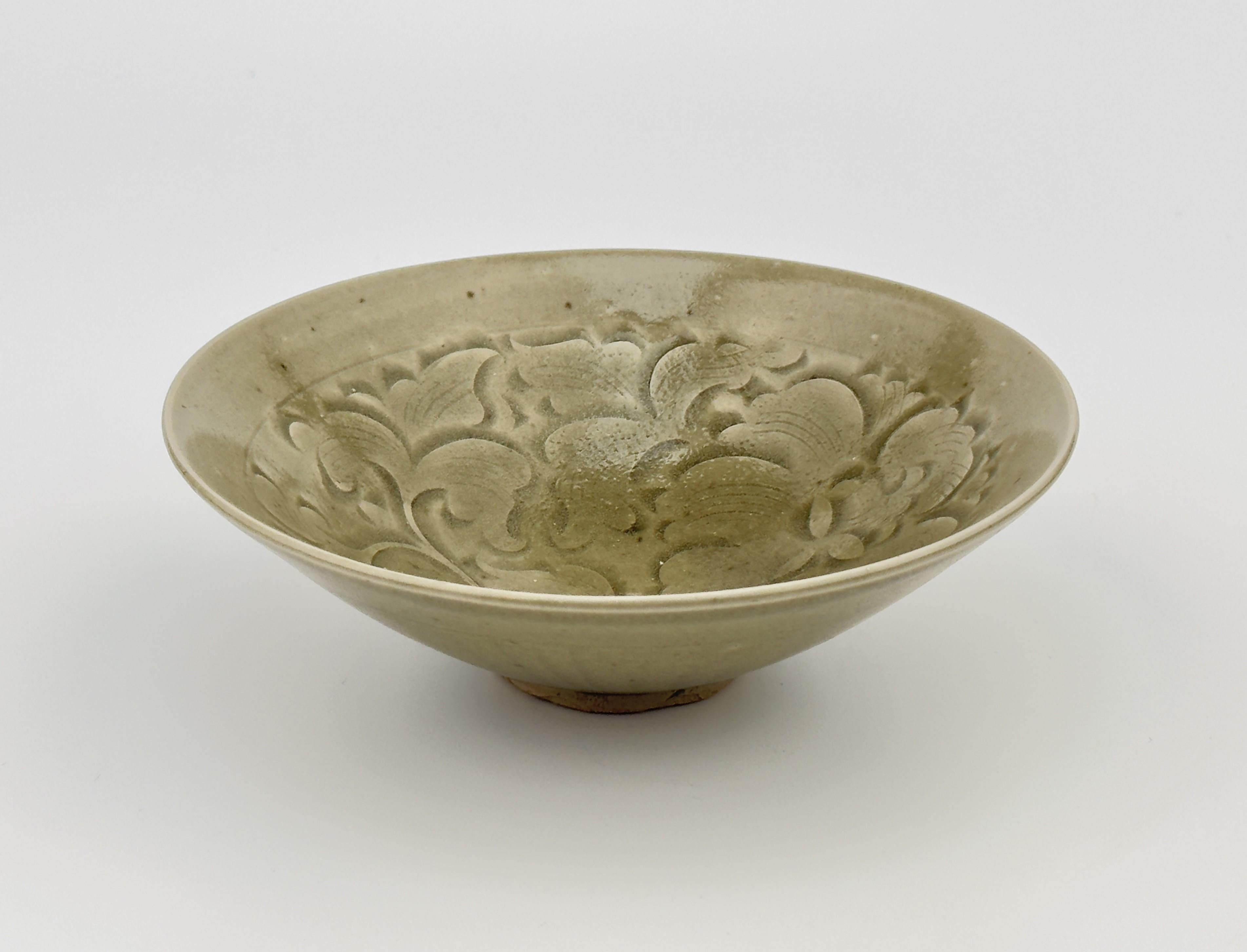 The bowl is potted with steep, flared sides and decorated to the interior with stylized peonies among scrolling tendrils. The exterior is carved with vertical lines below the everted mouth rim.

Period : Song Dynasty (AD 960~1279)
Type : Yaozhou