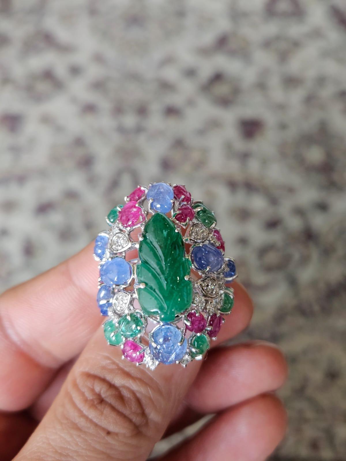A very gorgeous and beautiful, Blue Sapphires, Emeralds, Rubies Tutti Frutti Cocktail Ring set in 18K White Gold & Diamonds. The weight of the carved Emerald is 6.39 carats. The Emerald is completely natural, without any treatment and is of Zambian