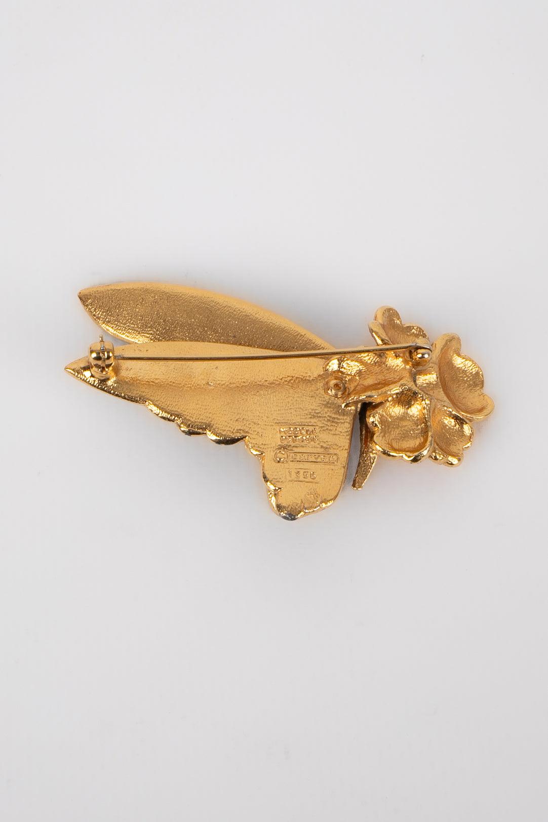 Carven - (Fabriqué en France) Broche en métal doré avec émail représentant un papillon récoltant du pollen sur une fleur.
 
 Informations complémentaires : 
 Condit : Très bon état.
 Dimensions : 6,5 cm x 4 cm : 6,5 cm x 4 cm
 
 Référence du vendeur