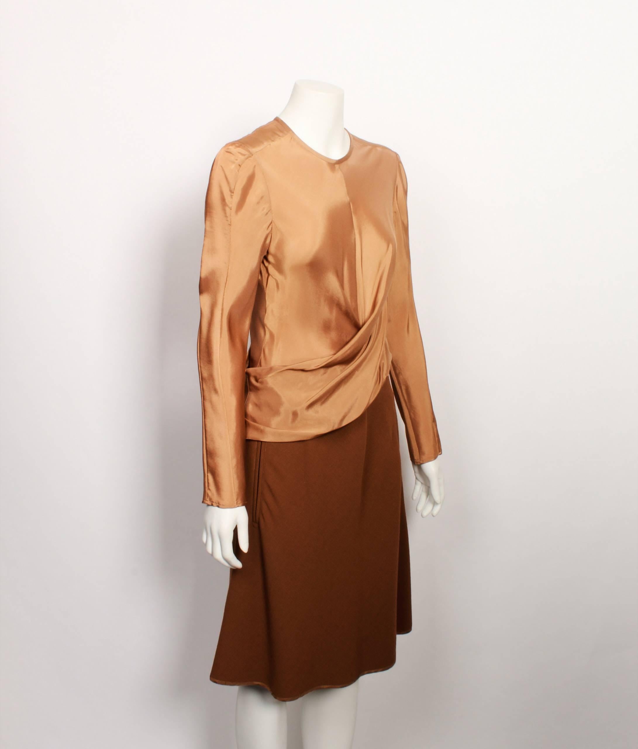 Carven long sleeved dress featured draped asymmetric bodice in matte satin. The skirt section of the dress is made from matte wool in tonal shades of caramel. 
The bodice has a fitted silhouette and the hemline is flared. Features two welt pockets