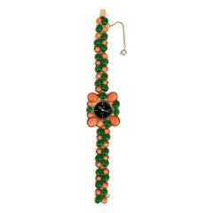 Reloj Carven de metal dorado pavimentado con cabujones de pasta de vidrio, años 60