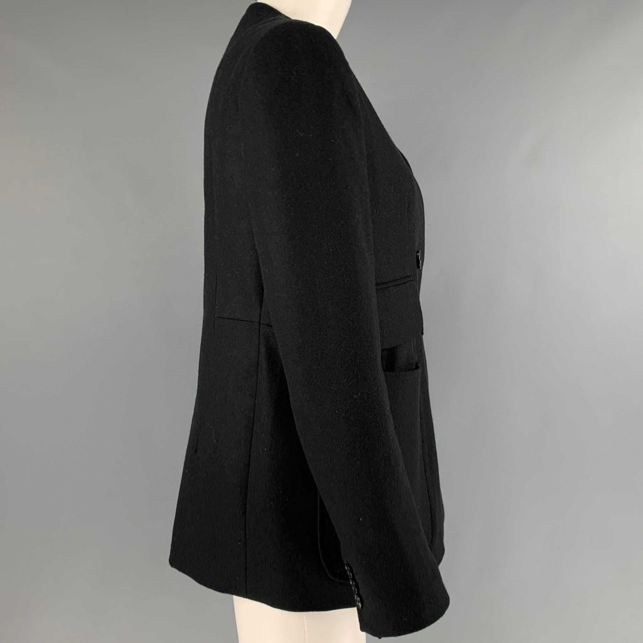 CARVEN jacket
in a black wool fabric featuring a double breasted style, large pockets, and a single button closure. Made in France.Excellent Pre-Owned Condition. 

Marked:   42 

Measurements: 
 
Shoulder: 16 inches Bust: 37 inches Sleeve: 24.5