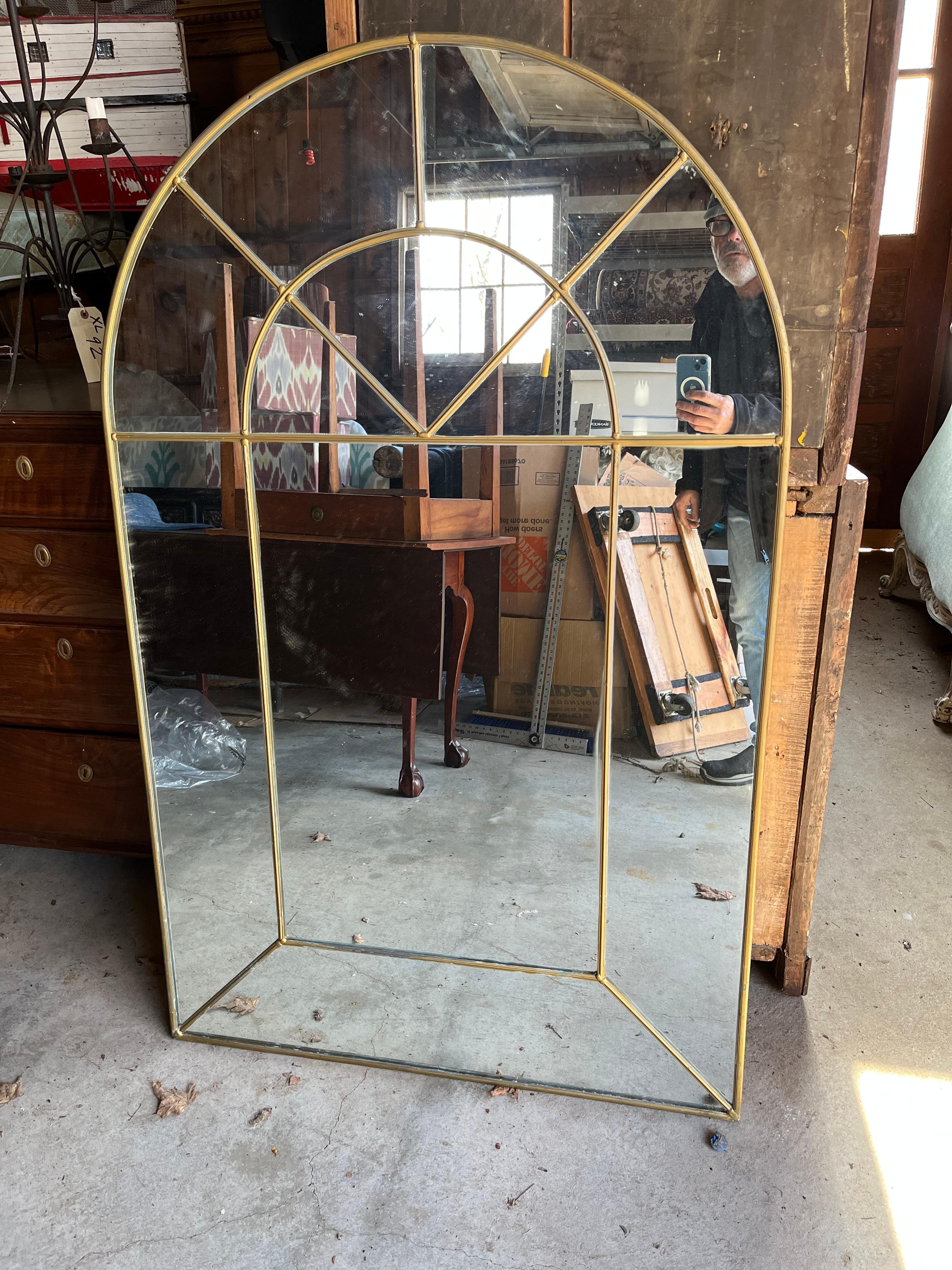 A “Colonial Arch” mirror designed by Carol Canner and made by Carver’s Guild, signed and dated on reverse, a matte gold finish to the metal. 

A second identical mirror is available to make a pair if needed. 