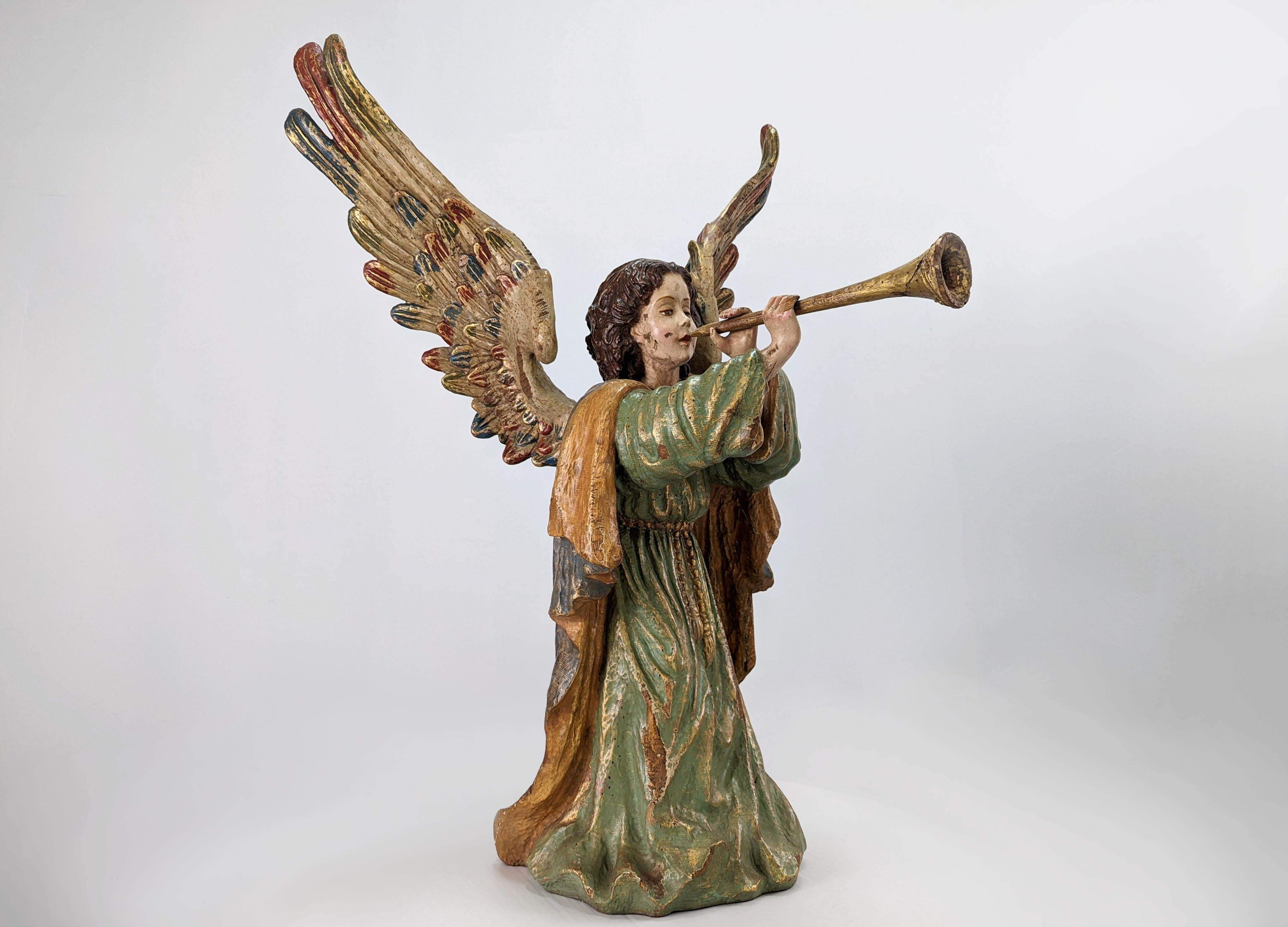 Impressive polychrome wood carving of an angel playing an instrument. Both the wings and the instrument can be removed. It shows signs of wear and has some breakage on the edges, such as the little angel's finger. The polychrome colors enhance the