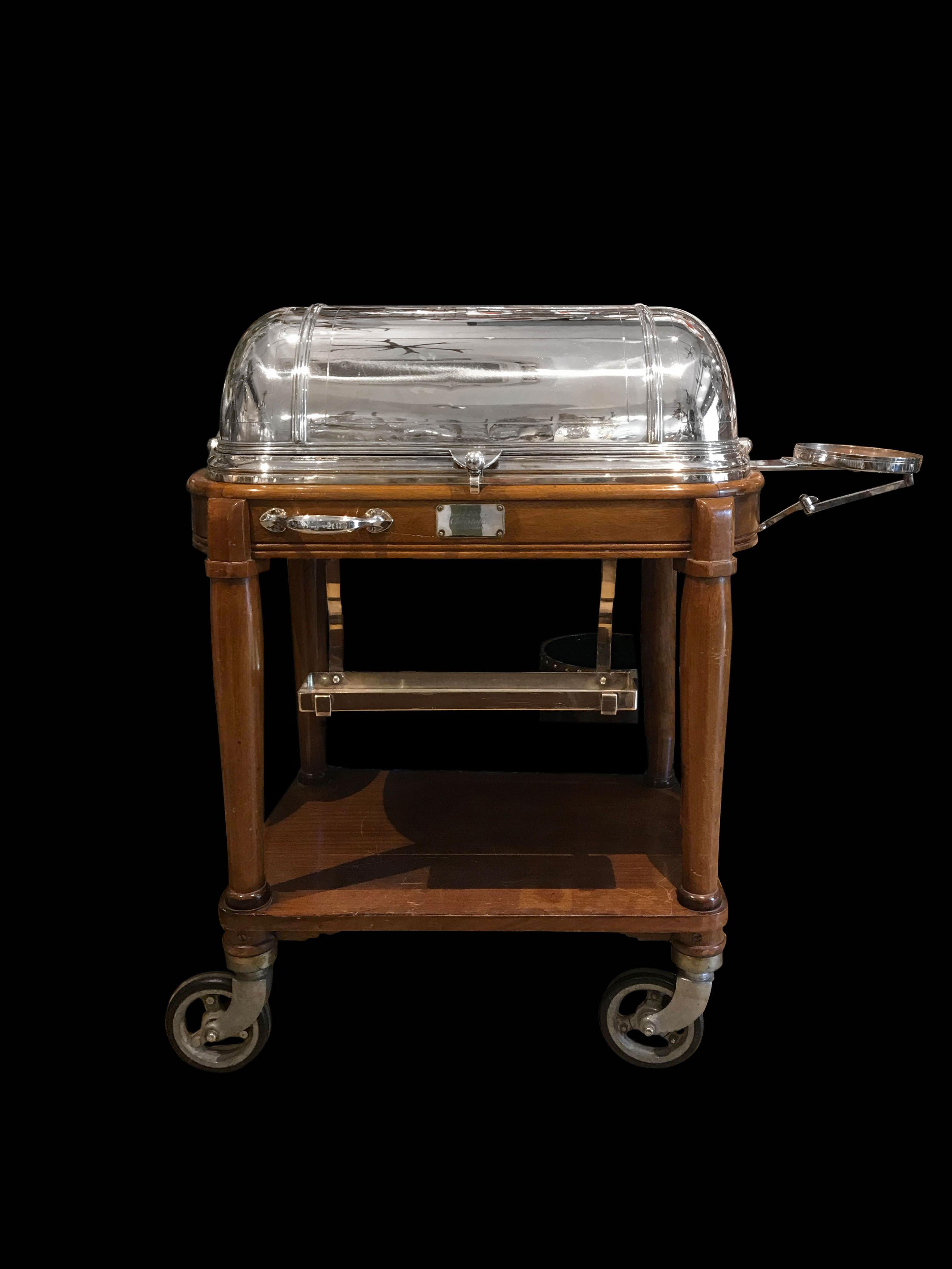 This French carving trolley crafted by the French world-famous silversmith Christofle.
The trolley is very practical to keep meals warm. Made of silver plated and stained wood, the trolley is oval-shaped and standing on four wheels which makes it