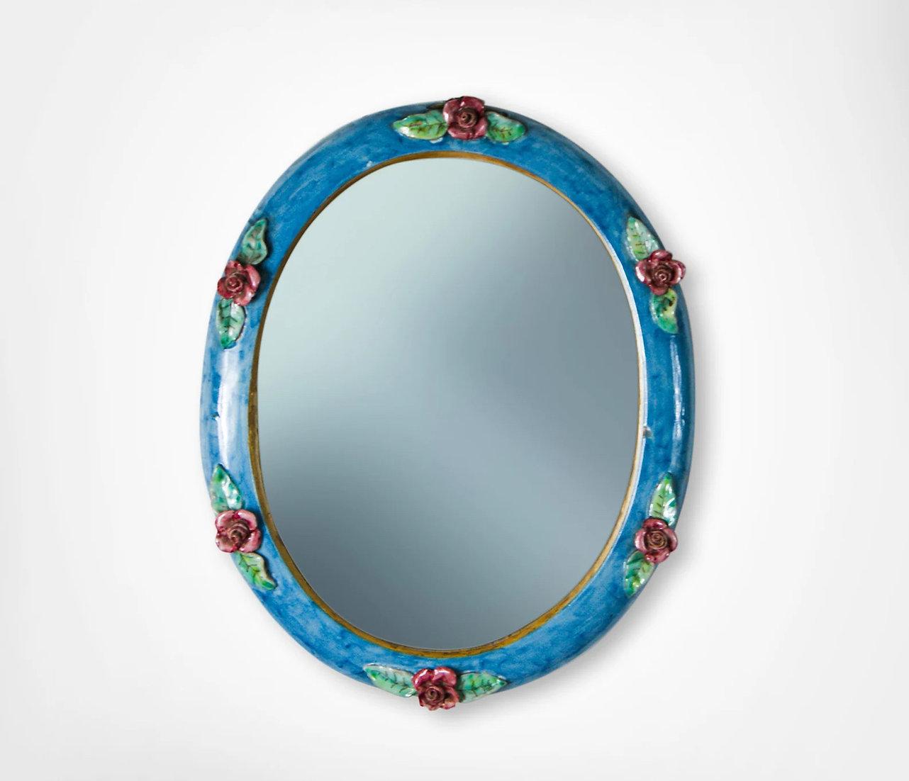 Attrayant miroir mural en céramique émaillée par C.A.S Vietri Italie, vers les années 1950.
Ravissant miroir mural de forme ovale avec bordure en céramique émaillée bleu vif.
Décoré avec des roses rouges appliquées et du feuillage...
Miroir très
