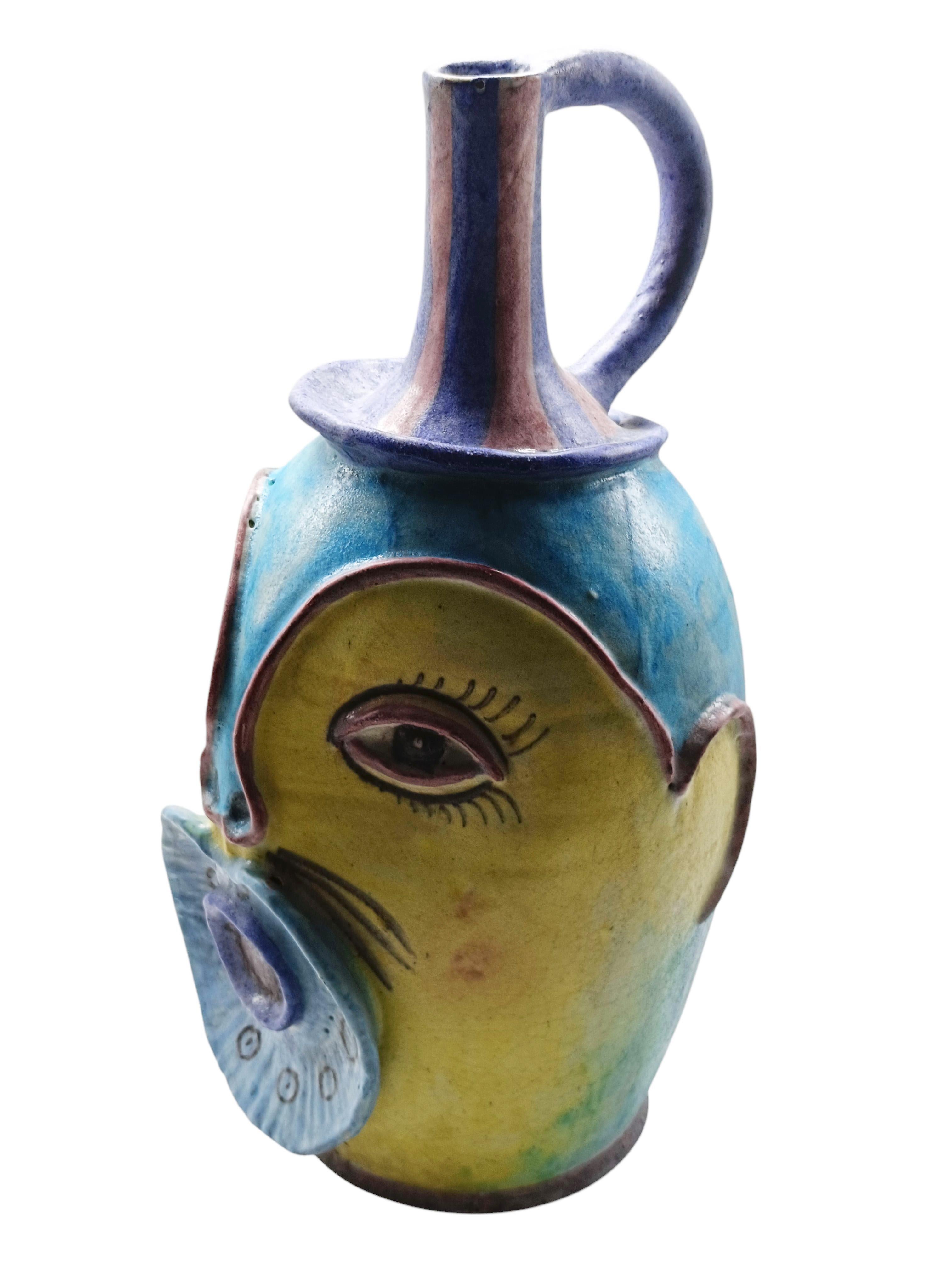 Raro e Grande vaso C.A.S. ( Ceramiche Artistiche Solimene ) Vietri Italy in ceramica smaltata, forma affusolata e leggermente bombata, con fattezze antropomorfe, che richiamano un volto stilizzato con grandi occhi e una bocca prominente. Il manico e