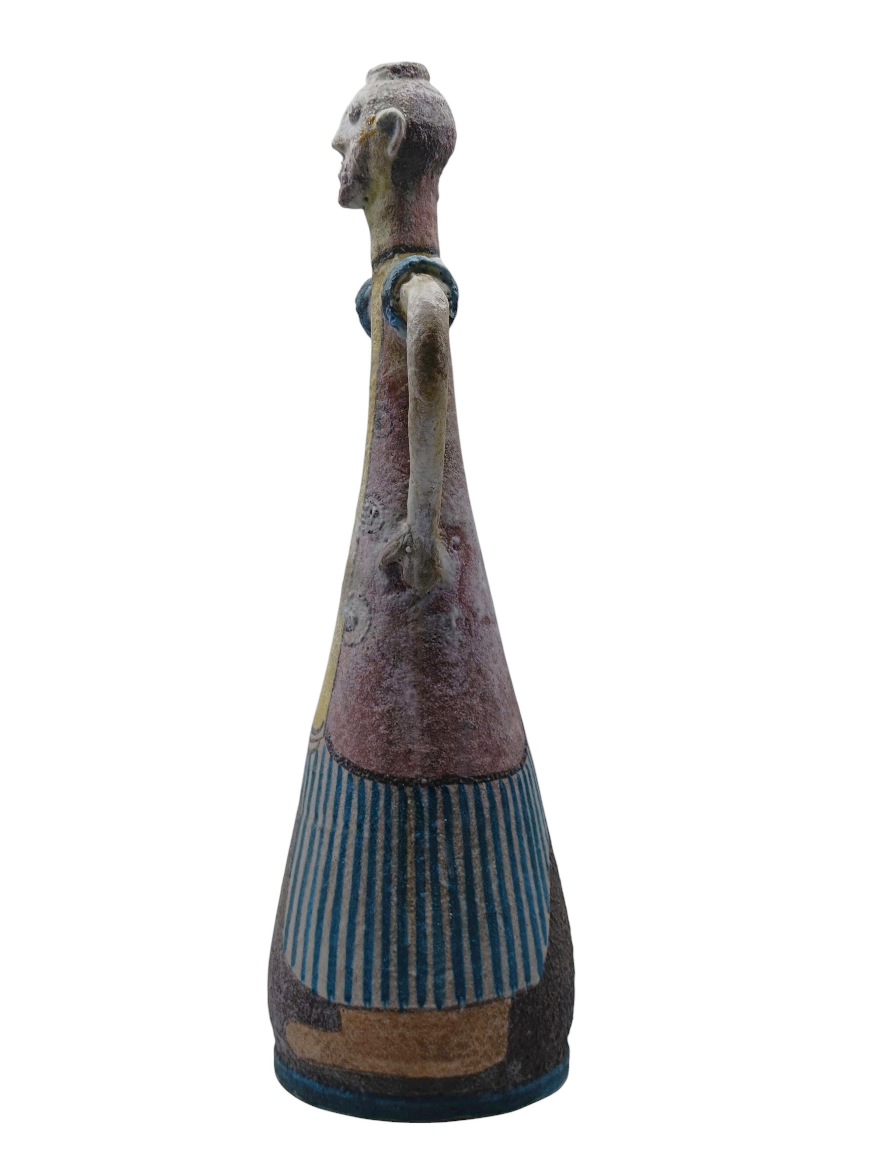 Vaso Monumentale Figurato in Ceramica C.A.S. ( Ceramiche Artistiche Solimene ) di Vietri, Italia.
Il vaso rappresenta una figura umana con decorazioni verticali a righe blu e bianche, la testa e' scolpita con tratti del viso marcati e visibili, le