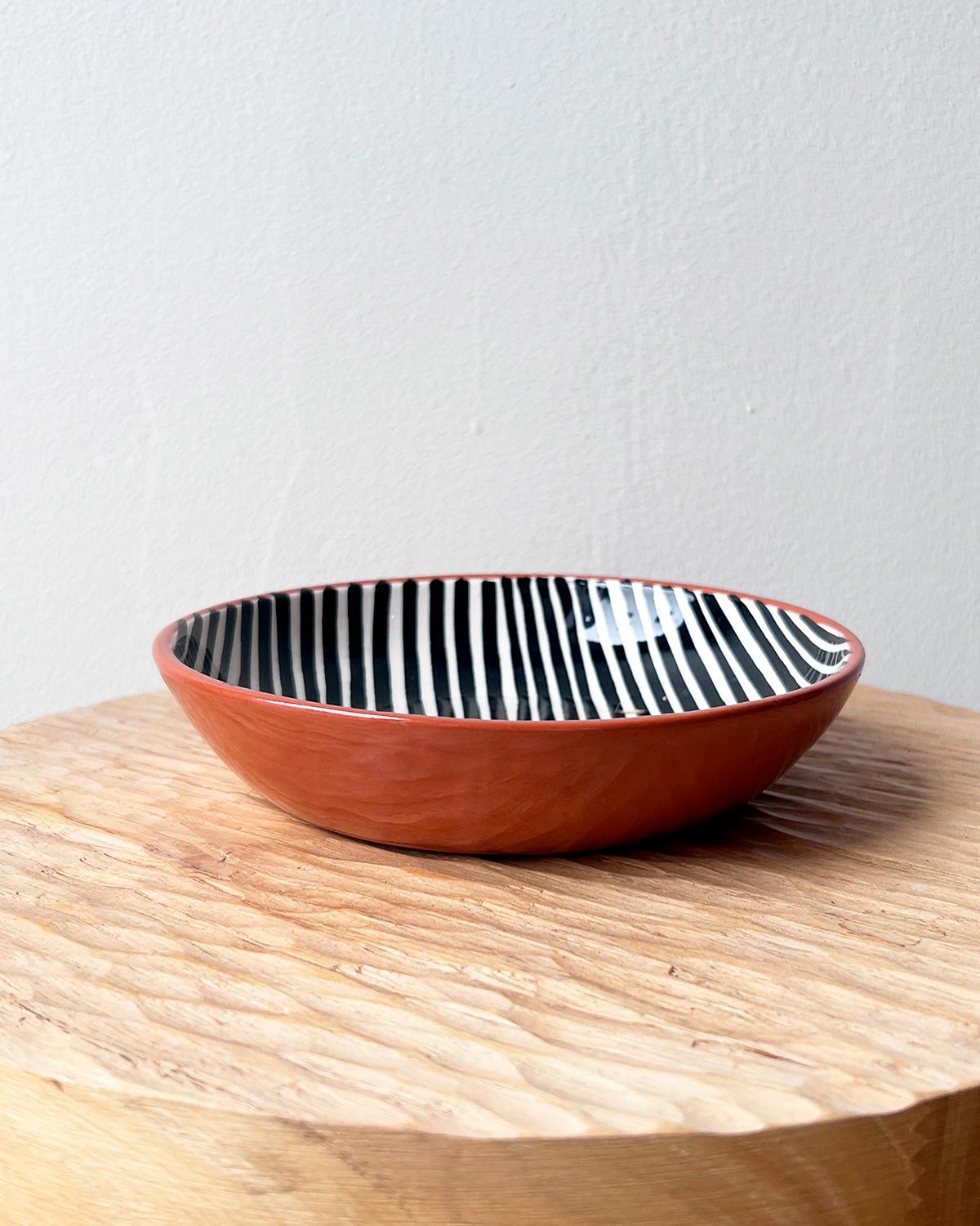 Piatti e ciotole in terracotta in bianco e nero con motivo a righe.

Realizzati e dipinti a mano in ceramica dal Portogallo meridionale, questi bellissimi pezzi per la tua tavola aggiungeranno un tocco moderno e grafico e sono perfetti da