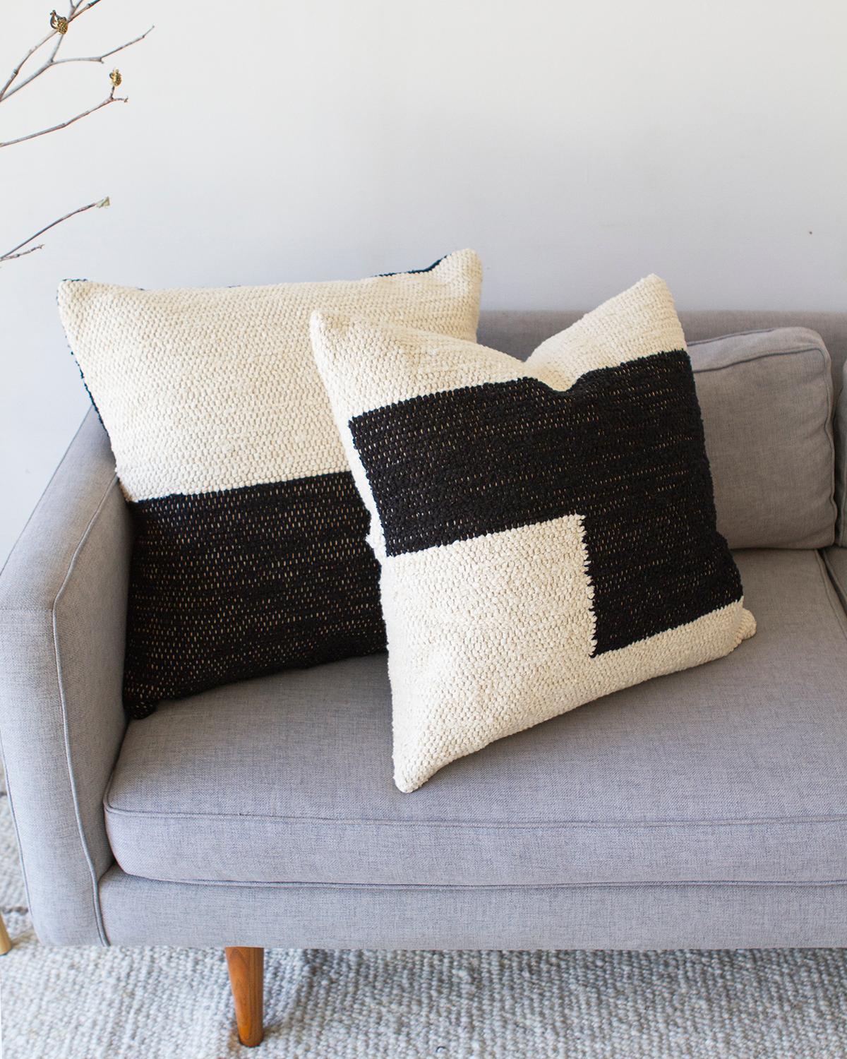 Un cuscino a trama geometrica per il divano o il letto. Questo cuscino in cotone nero e crema è realizzato in cotone intrecciato a mano ed è perfetto per una zona ad alto traffico come il divano del soggiorno. Metti due cuscini coordinati su