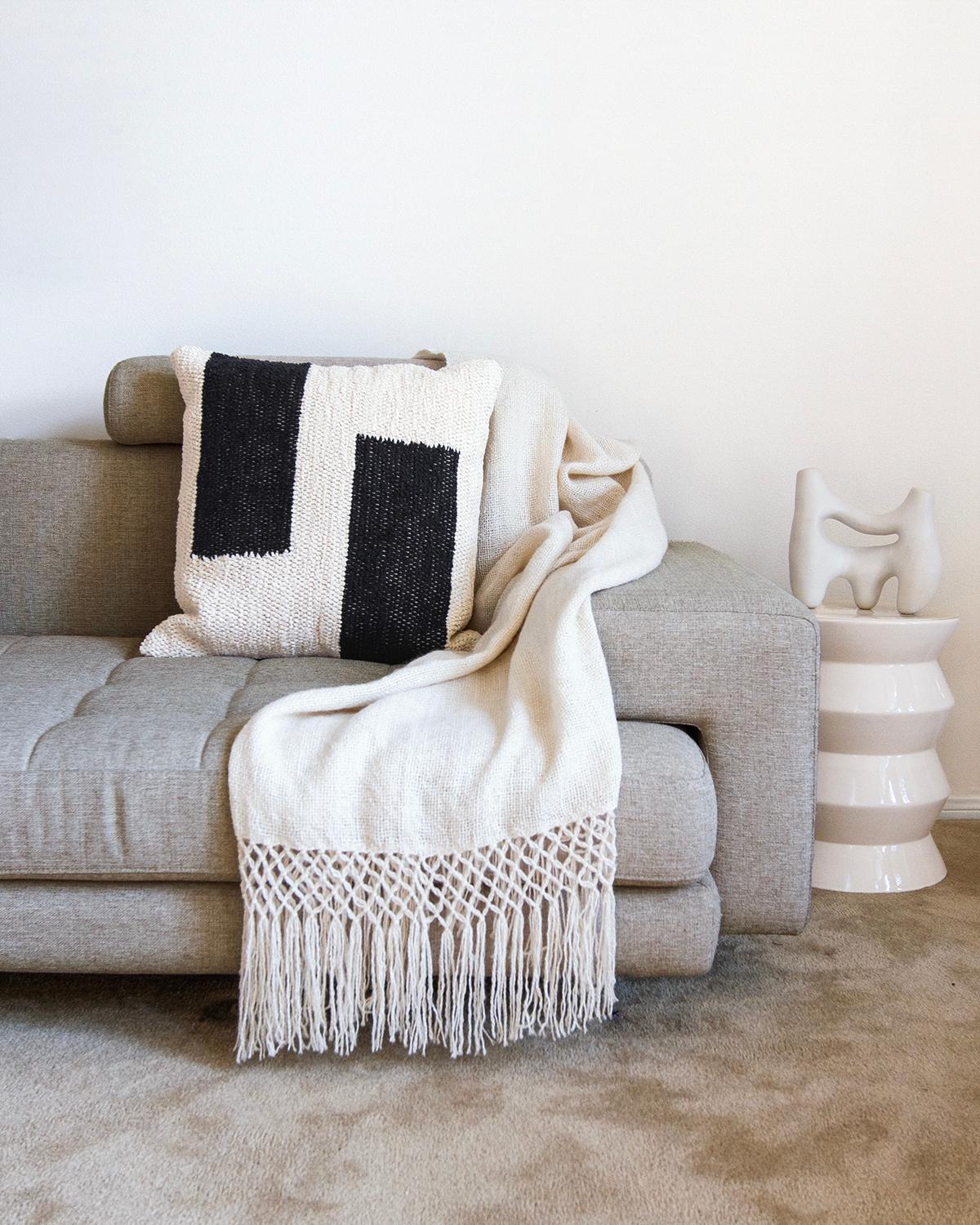 A geometric textured throw pillow for your couch or bed. This black and cream cotton throw pillow is made from this handwoven cotton and is perfect for a high traffic area like the living room couch. Put two matching pillows on either side of the