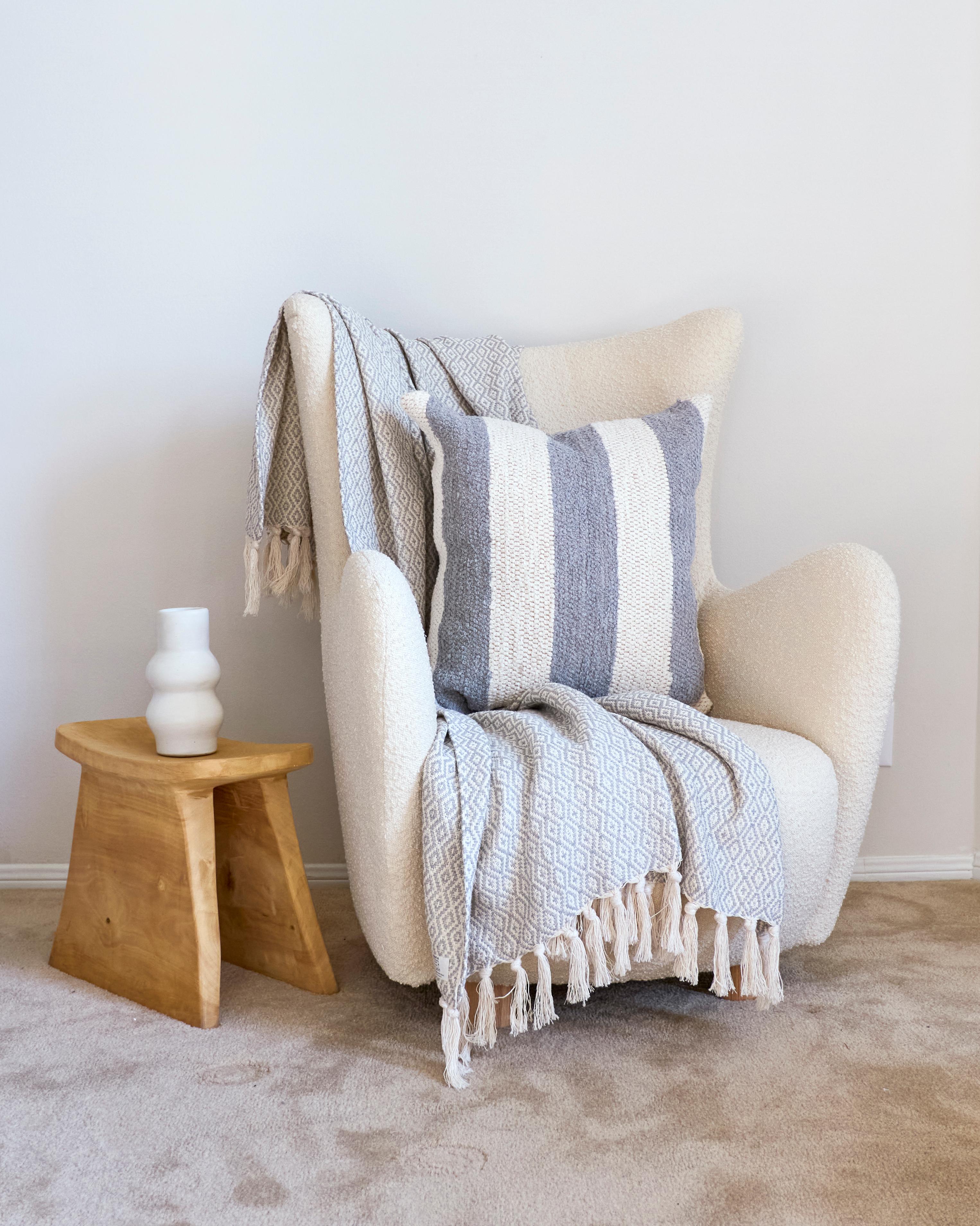 Cuscino a blocchi di colore grigio, audace e grafico, realizzato in 100% cotone riciclato proveniente dall'industria della moda e da uno dei paesi madre, il Portogallo. Questo cuscino intrecciato a mano sarà elegante in qualsiasi casa moderna o