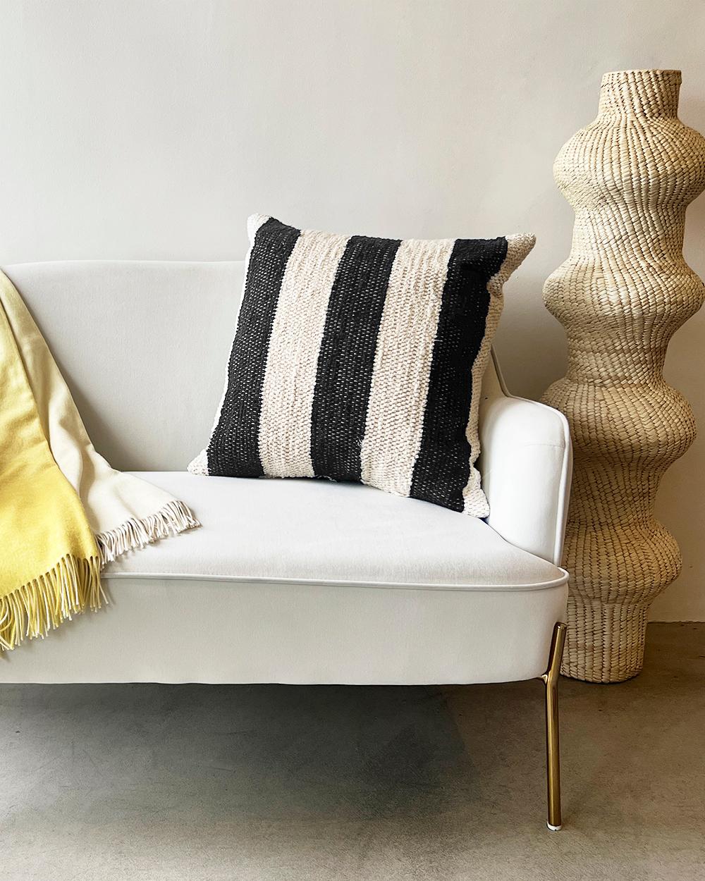 A geometric textured throw pillow for your couch or bed
This black and cream cotton throw pillow is made from thick handwoven cotton and is perfect for a high traffic area like the living room couch. Put two matching pillows on either side of the