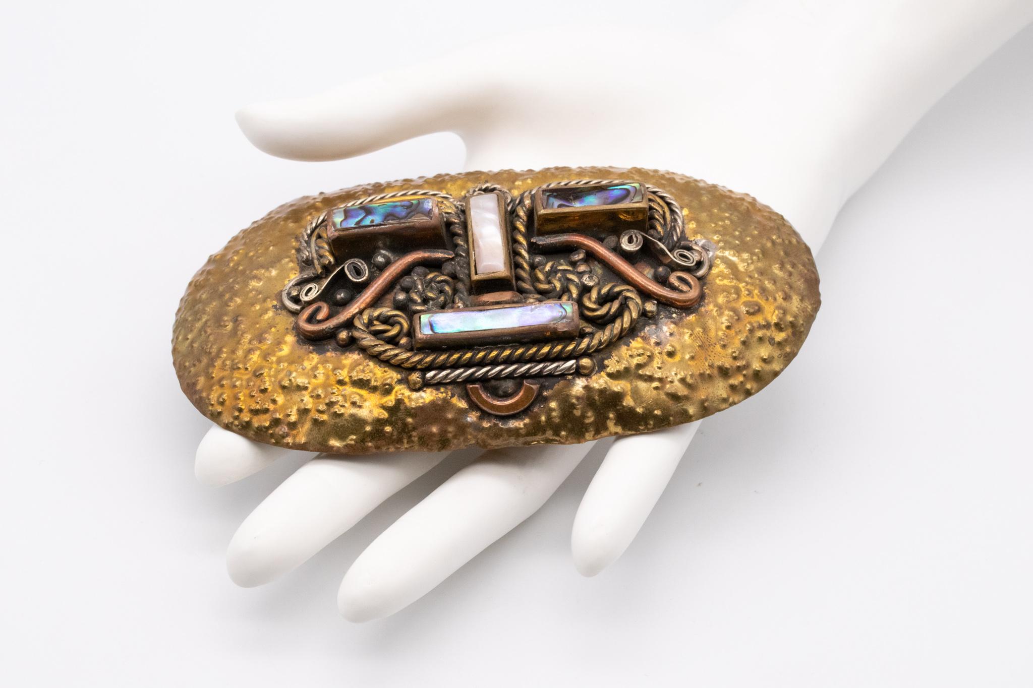 Statement belt-buckle pendant designed by Casa De Maya.

A rare vintage piece, created in Mexico during the mid-century back in the 1950. Crafted at the atelier of Casa De Maya with mixed metals such hammered copper and polished brass. This