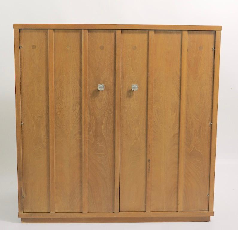 Stylish architectural two-door cabinet with interior drawers and shelves. This cabinet can serve as a chest of drawers, wardrobe, or diminutive armoire. Well crafted, in good untouched original condition, clean and ready to use. The finish shows