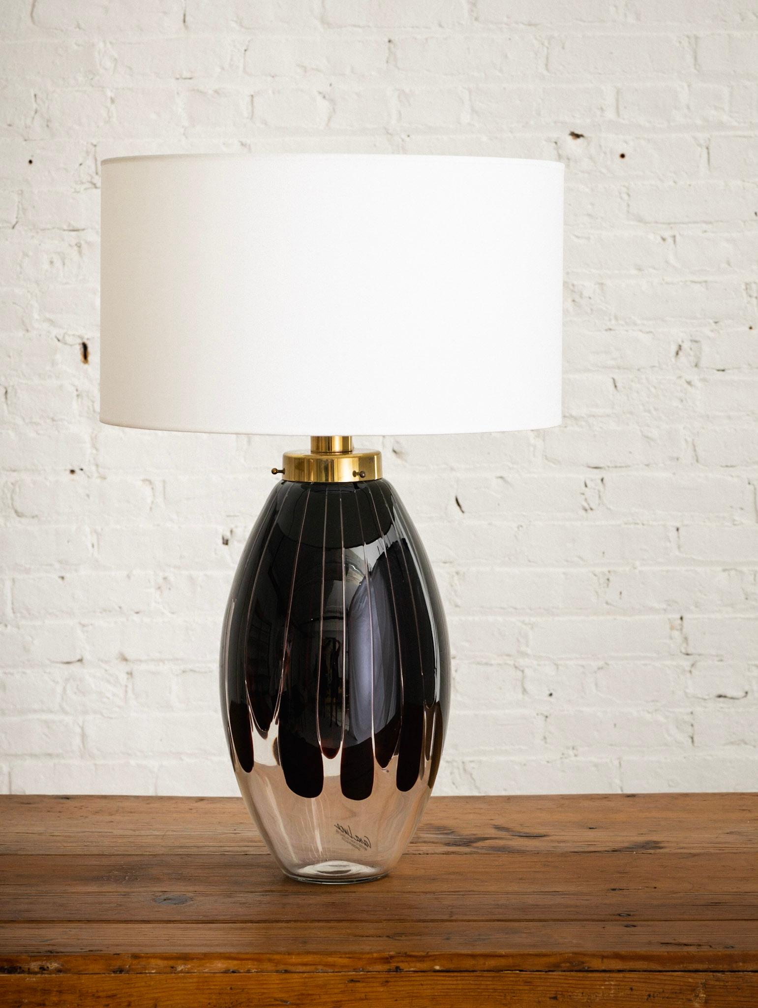 Eine italienische Tischlampe, hergestellt von Casa Luce für Scandinavian Gallery. Transparentes Glas mit einer dunklen bernsteinfarbenen/molassesfarbenen Tropfenform. Beschläge aus Messing. Die Lampe verfügt über eine obere und eine innere
