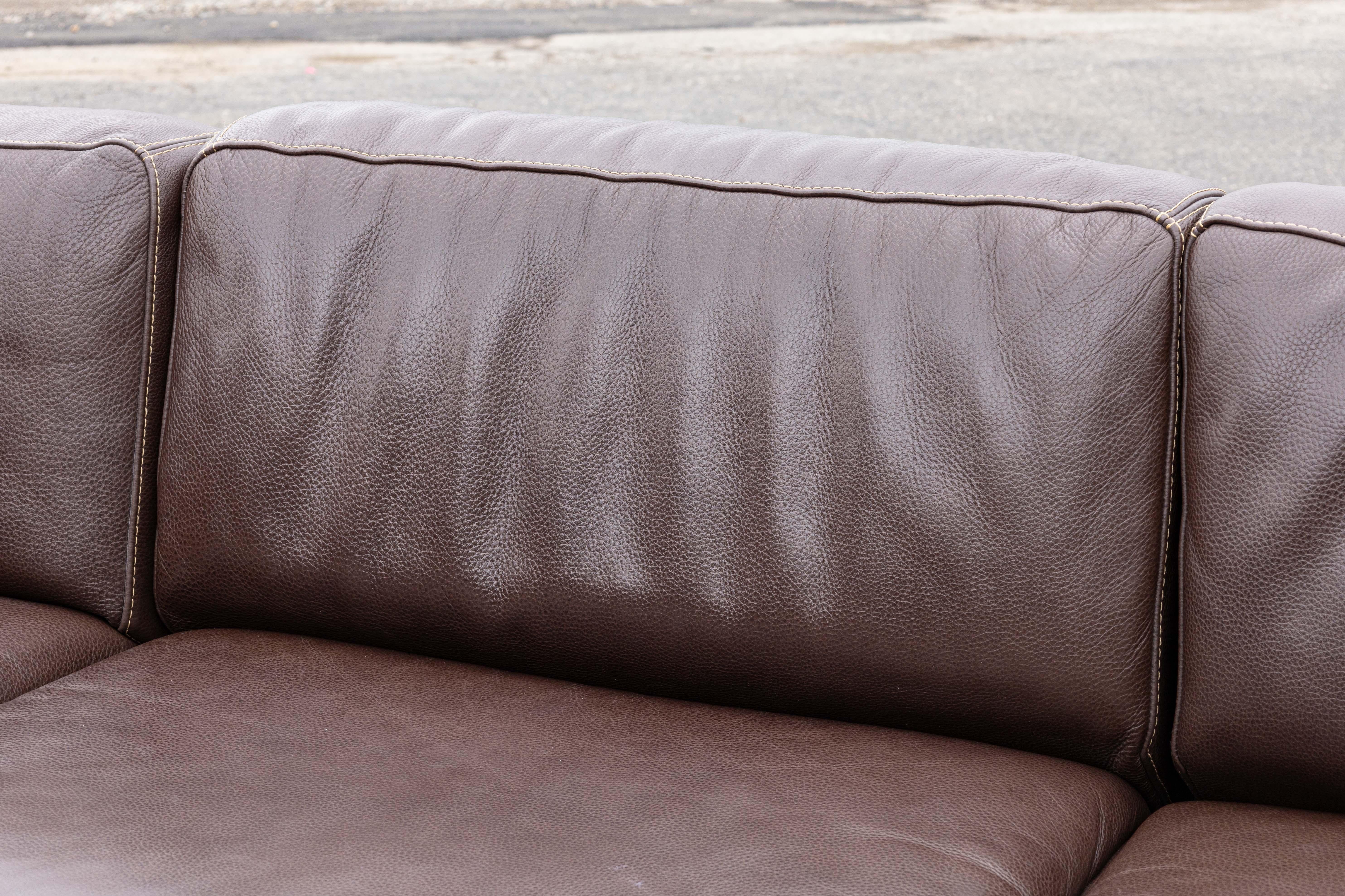 A Casa Novalia brown leather sectional sofa. This outstanding sectional sofa features a lovely contemporary design. With a beautiful modern silhouette, this piece boasts supple, soft, brown leather with detailed beige stitching that catches the eye.