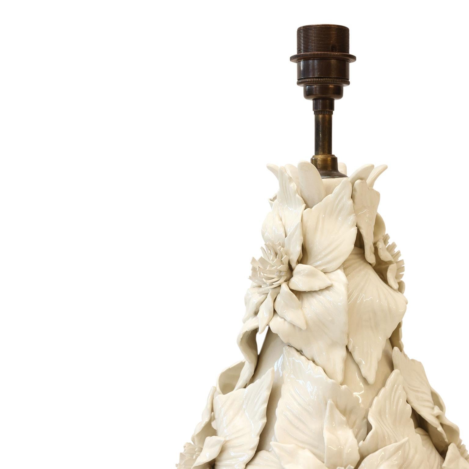 Casa Pupo table lamps: large-scale pair of off-white ceramic table lamps from Spain. Each lamp covered in decorative white ceramic flowers. Mounted upon a gilded base and newly wired for use within the USA. Originally sold in the 1960s in a London