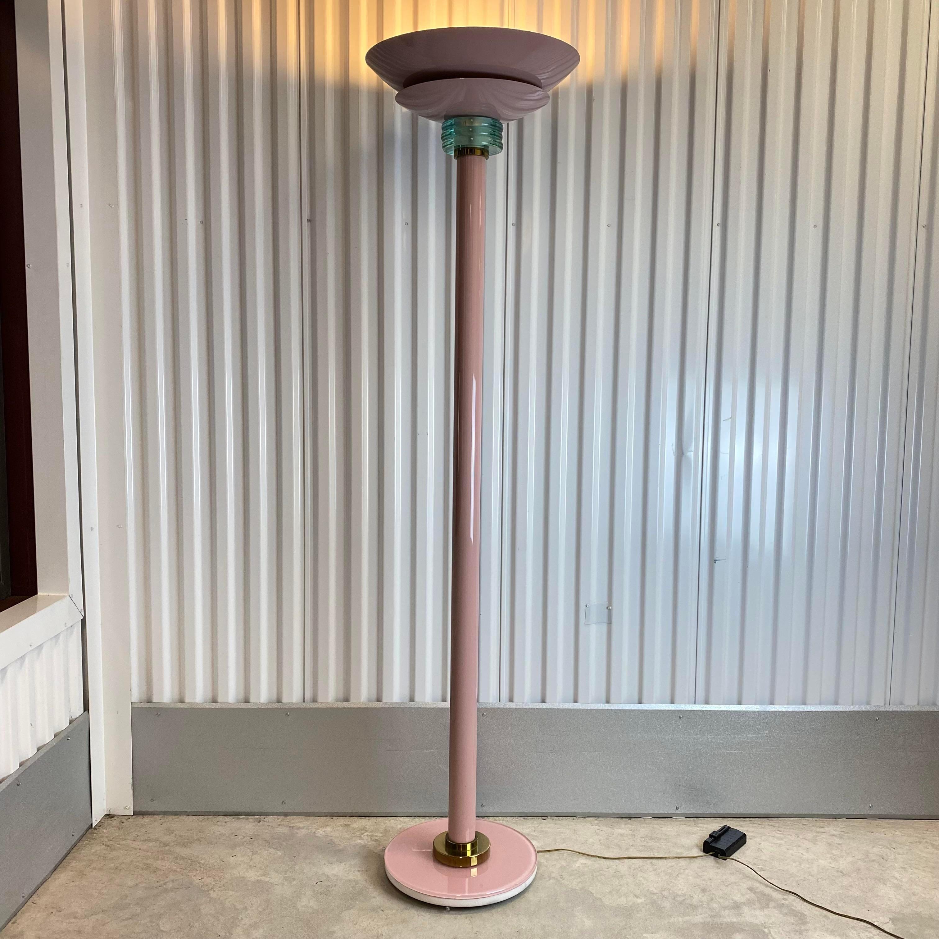 Vintage circa 1980s mauve floor lamp
Lamp body consists of glass at the top and base with mauve lacquered metal and brass accents
A marble weight is used at the bottom under mauve glass base to sturdy the tall lamp
Lamp uses two bulbs and has a