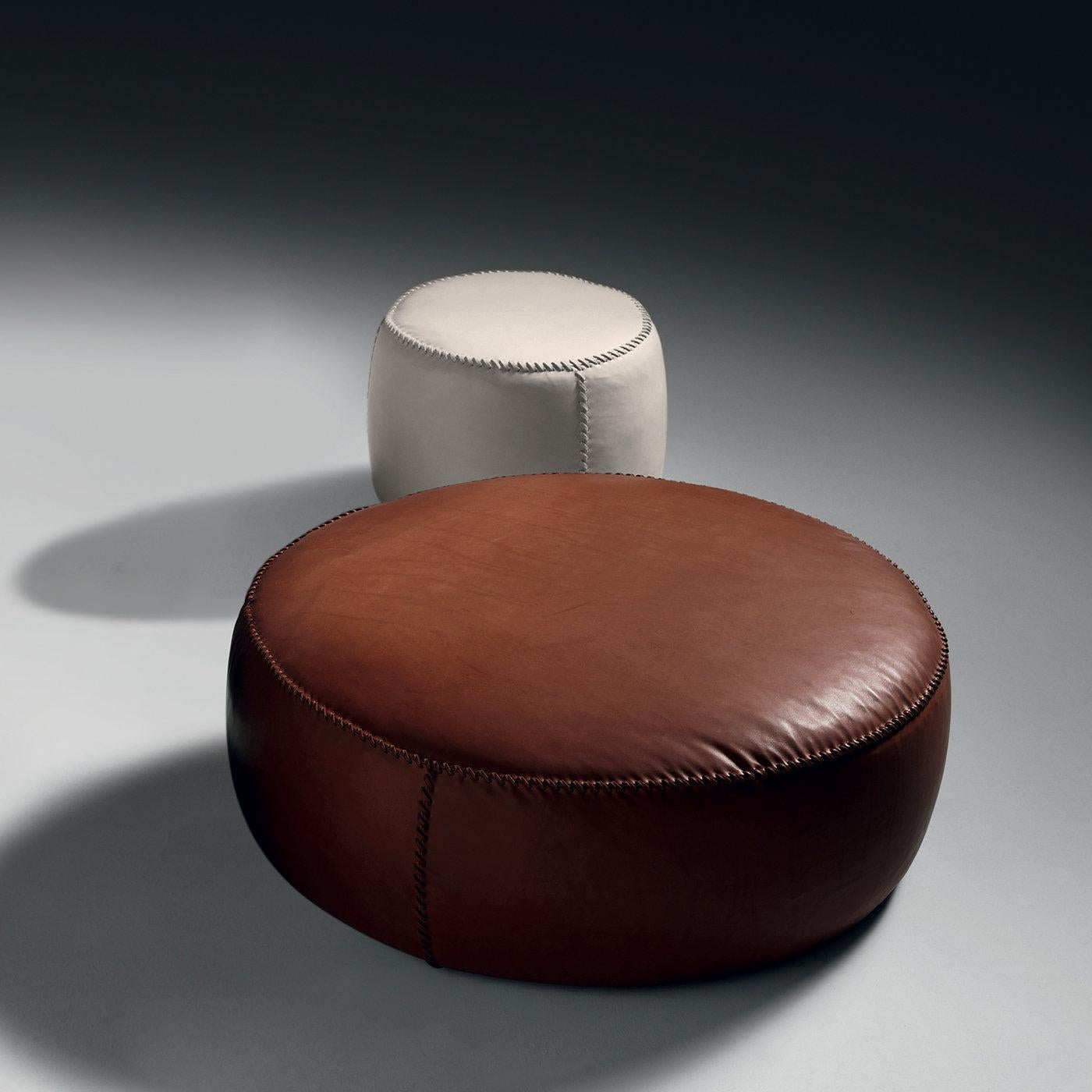 This leather pouf boasts a delicate ivory color that will infuse sophistication in any modern interior. It features a poplar wood structure padded with multi-density and highly-resistant polyurethane foam, combined with 100% European goose feathers