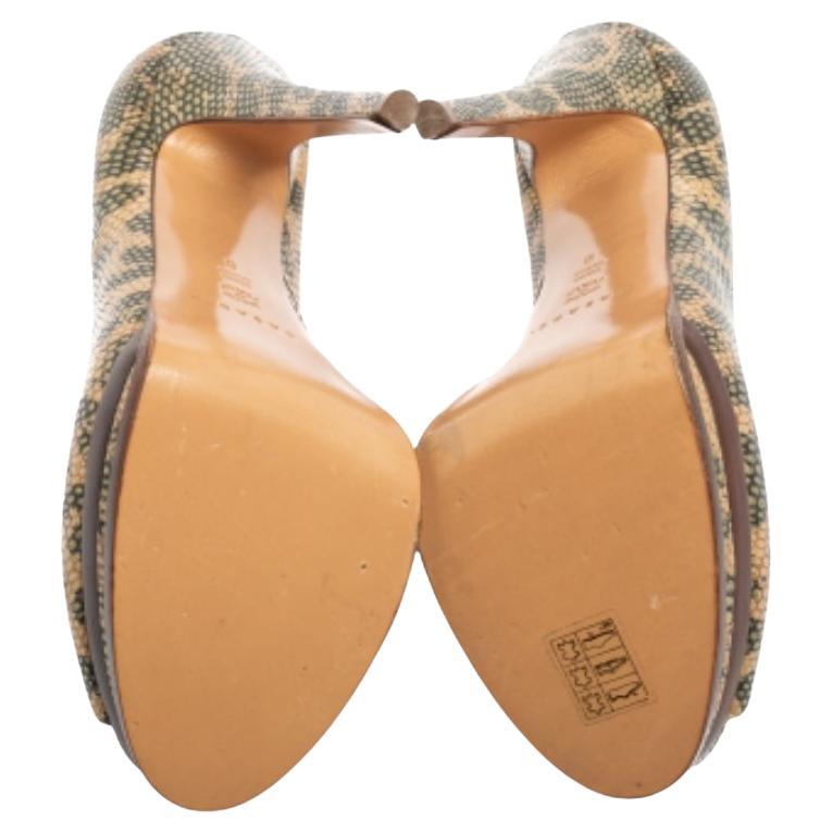 Deja que estos zapatos de salón de la Casa Casadei sean tus favoritos. Están hábilmente confeccionados en piel con relieve de lagarto beige verdoso en el exterior y lucen peep-toes, plataformas y altísimos tacones de 15 cm. Son de tipo slip-on.
