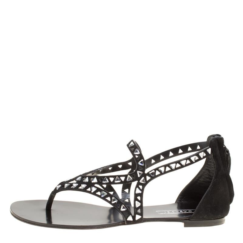 Comfort and Fashion combine to bring forth these wonderful black sandals from Casadei. These flat sandals are crafted from suede and feature a thong design. The cutouts and the crystal embellishments make the pair look amazing. Comfortable leather