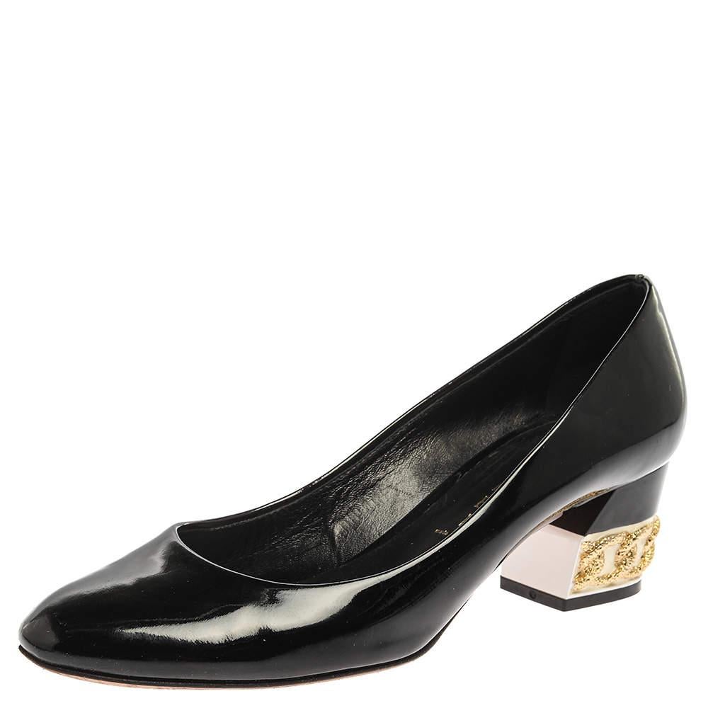 Casadei gives a modern turn to these classic black pumps, and there's no reason why you shouldn't get them for yourself. Crafted from glossy patent leather, these pumps are complete with 5 cm block heels accented with chain embellishments. 