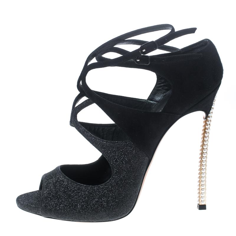 Shimmering and scintillating, these Hollywood pumps from Casadei are love at first sight! The black pumps are crafted from suede and glitter and feature a peep-toe silhouette. They flaunt a cutout design throughout and come equipped with buckled
