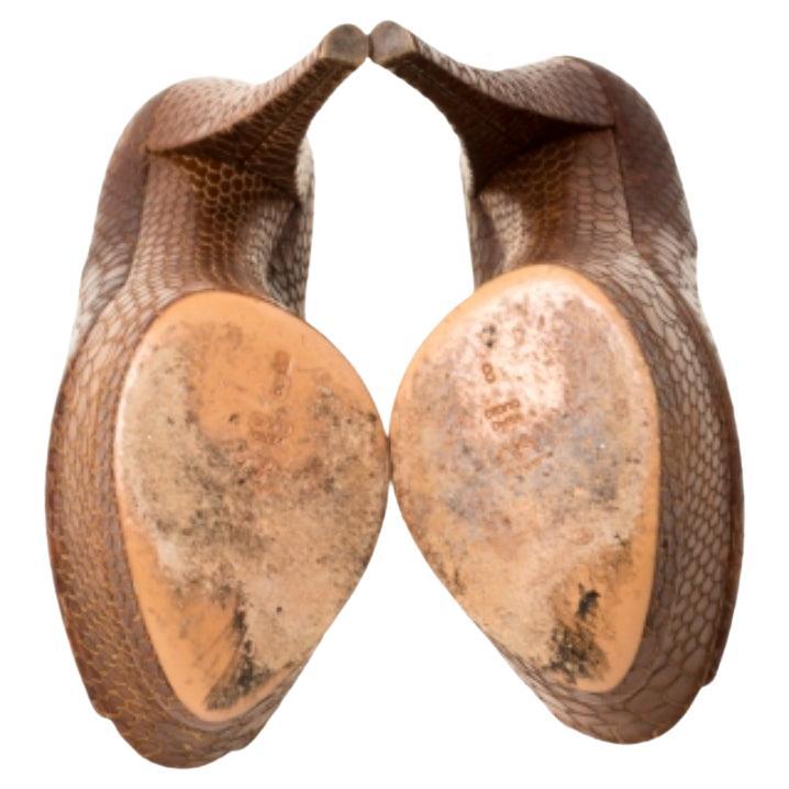 Faites de la rue votre piste de mode avec ces escarpins spectaculaires de Casadei. Chic en marron, ces escarpins sont confectionnés en cuir embossé de python et présentent une silhouette à bouts pointus. Ils sont dotés de solides plates-formes, de