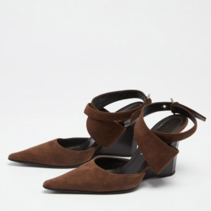 Los dedos puntiagudos, el cierre cruzado en el tobillo y los tacones elegantes de 10 cm realzan la belleza de estas sandalias Casadei. Los zapatos son de ante marrón y están forrados de cuero negro.